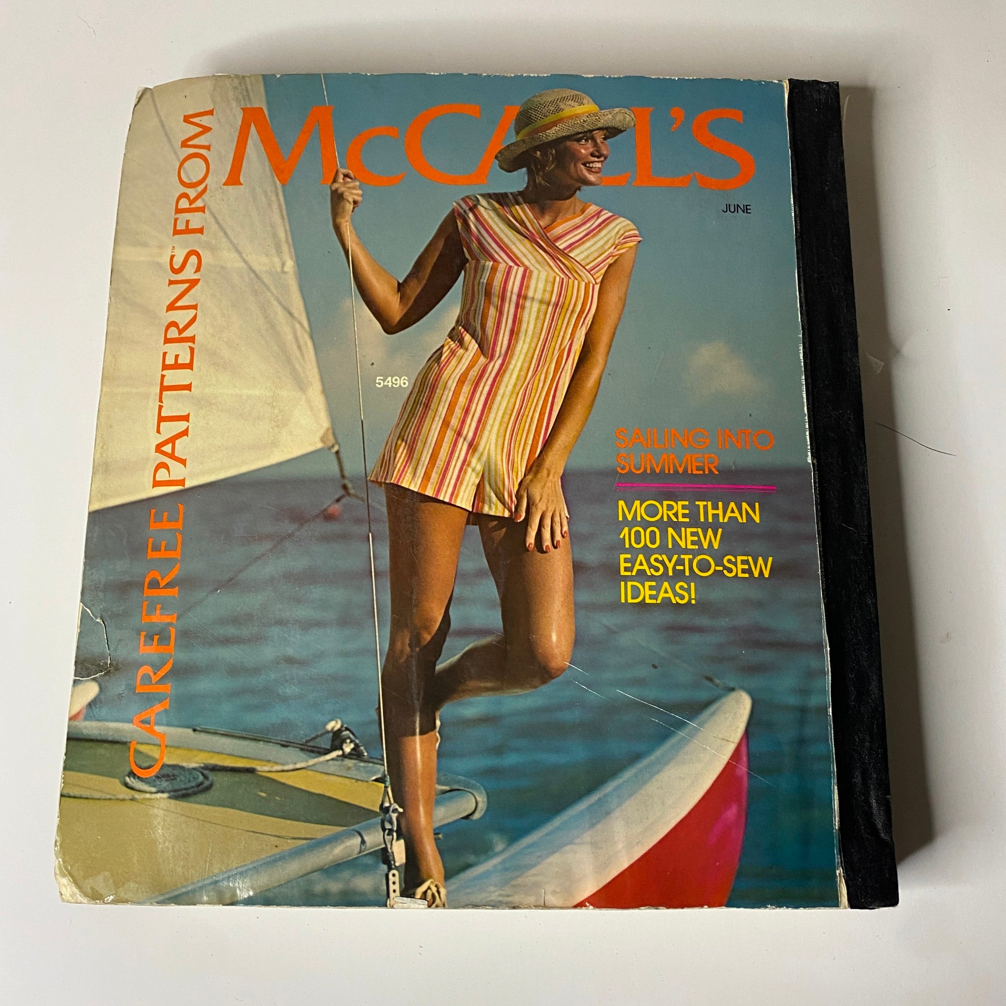 1970s June Carefree Patterns from McCall's Huge Store Retail Counter Catalog cover, featuring a woman in a striped summer outfit on a sailboat, promoting easy-to-sew fashion designs.