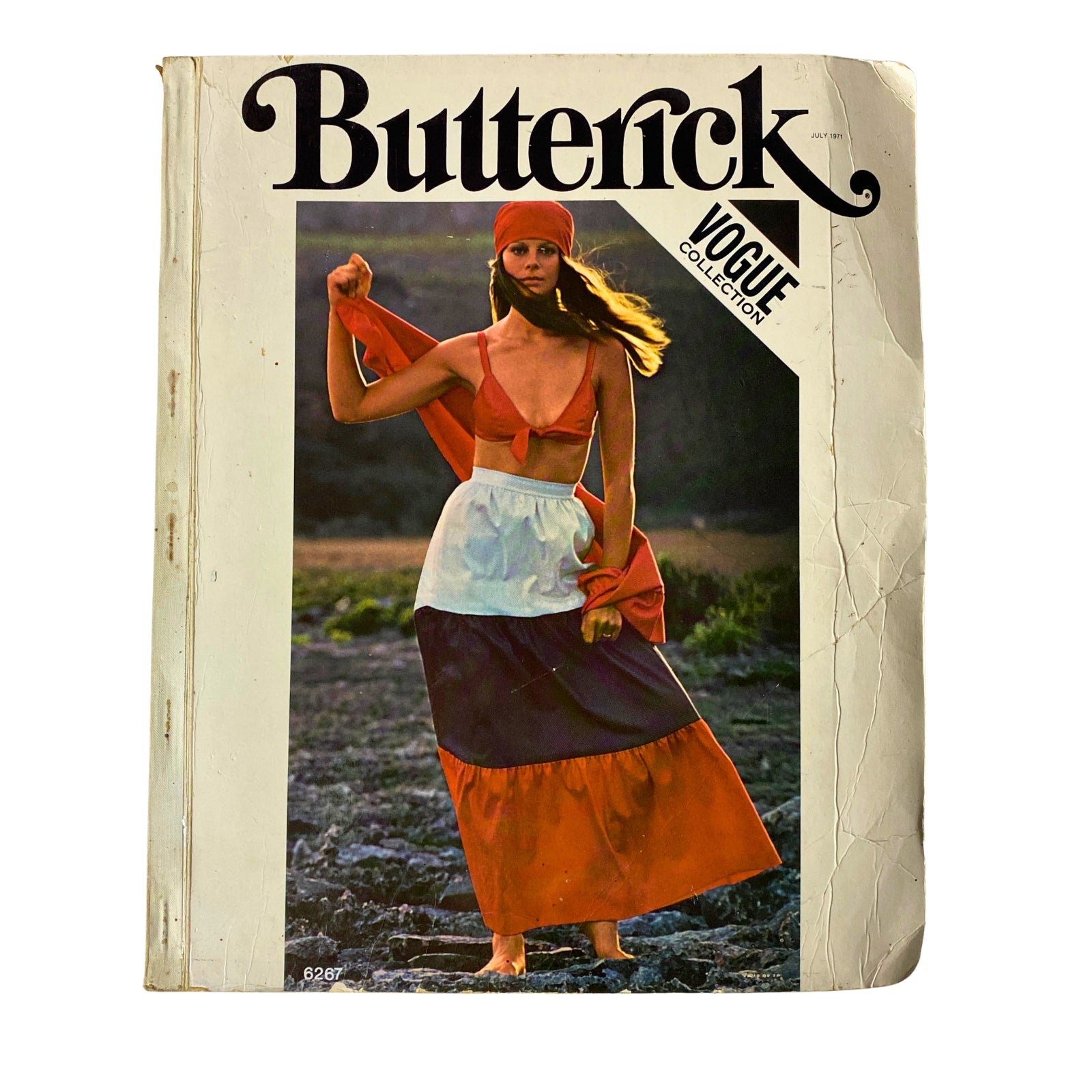 1971 July Butterick Vogue Collection Catalog featuring a model in a colorful two-tone long skirt and crop top, evoking vintage fashion inspiration.