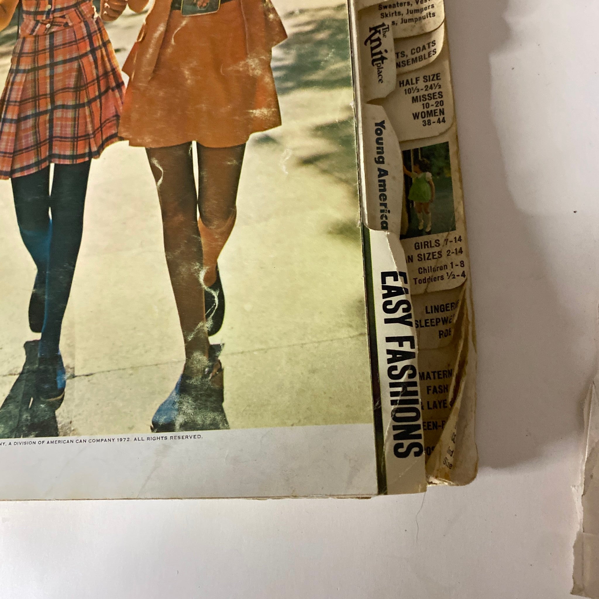 1972 May Butterick Catalog featuring a close-up of two girls modeling vibrant dresses, demonstrating early '70s fashion trends. Ideal for sewing enthusiasts.