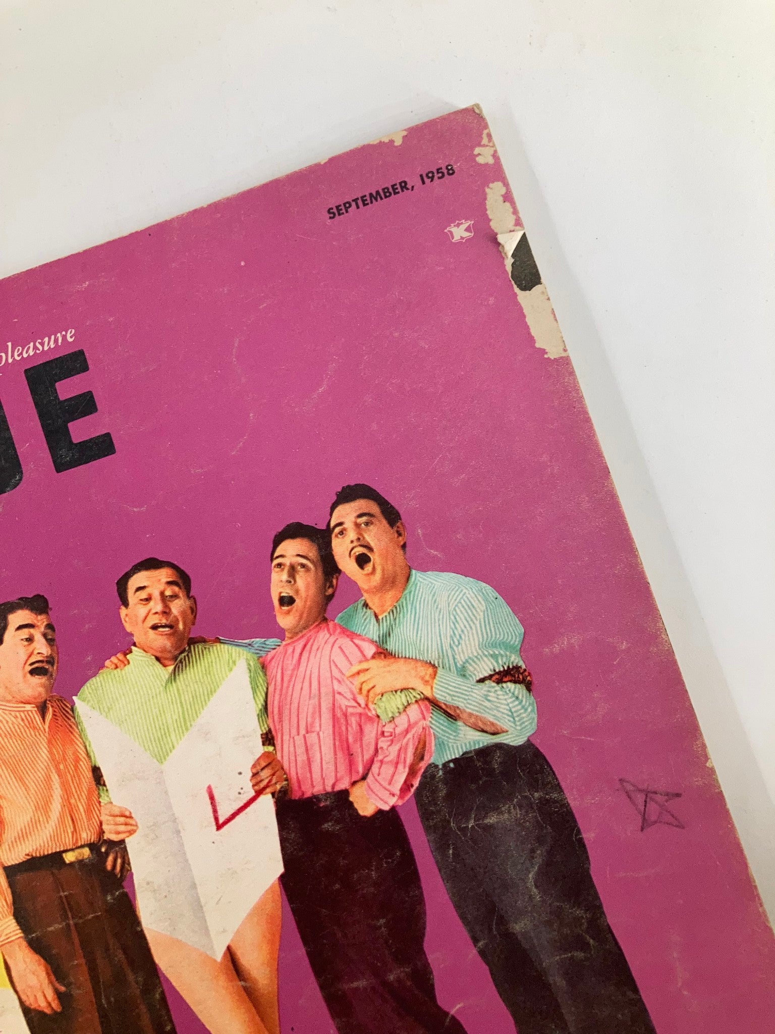 Close-up of the cover of VTG The Dude Magazine September 1958, showcasing the title and the enthusiastic expressions of four men in vibrant attire.