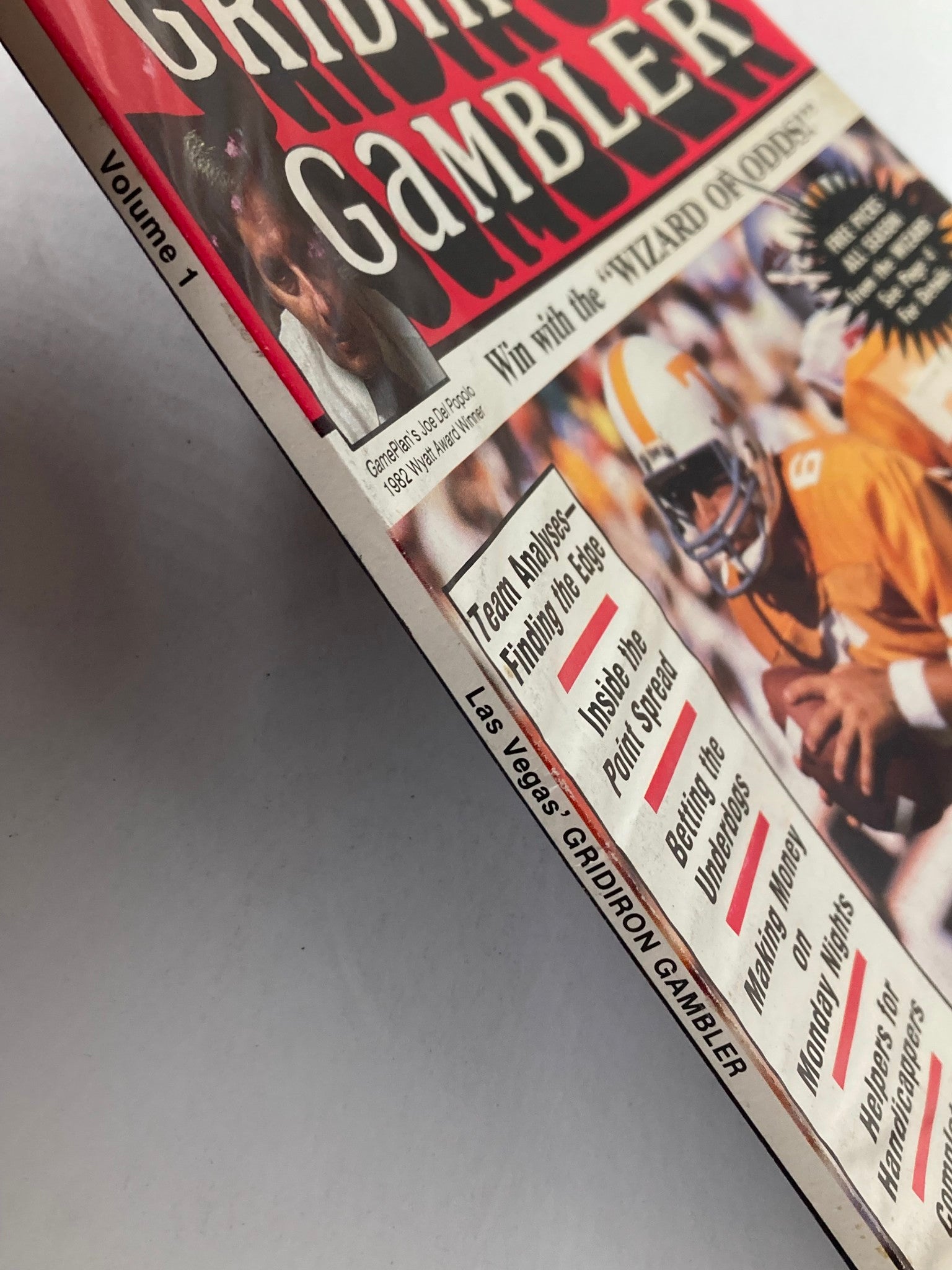Side view of VTG Las Vegas' Gridiron Gambler Magazine Vol 1 1982 showing its spine and detailed cover description including features on betting and football analysis.