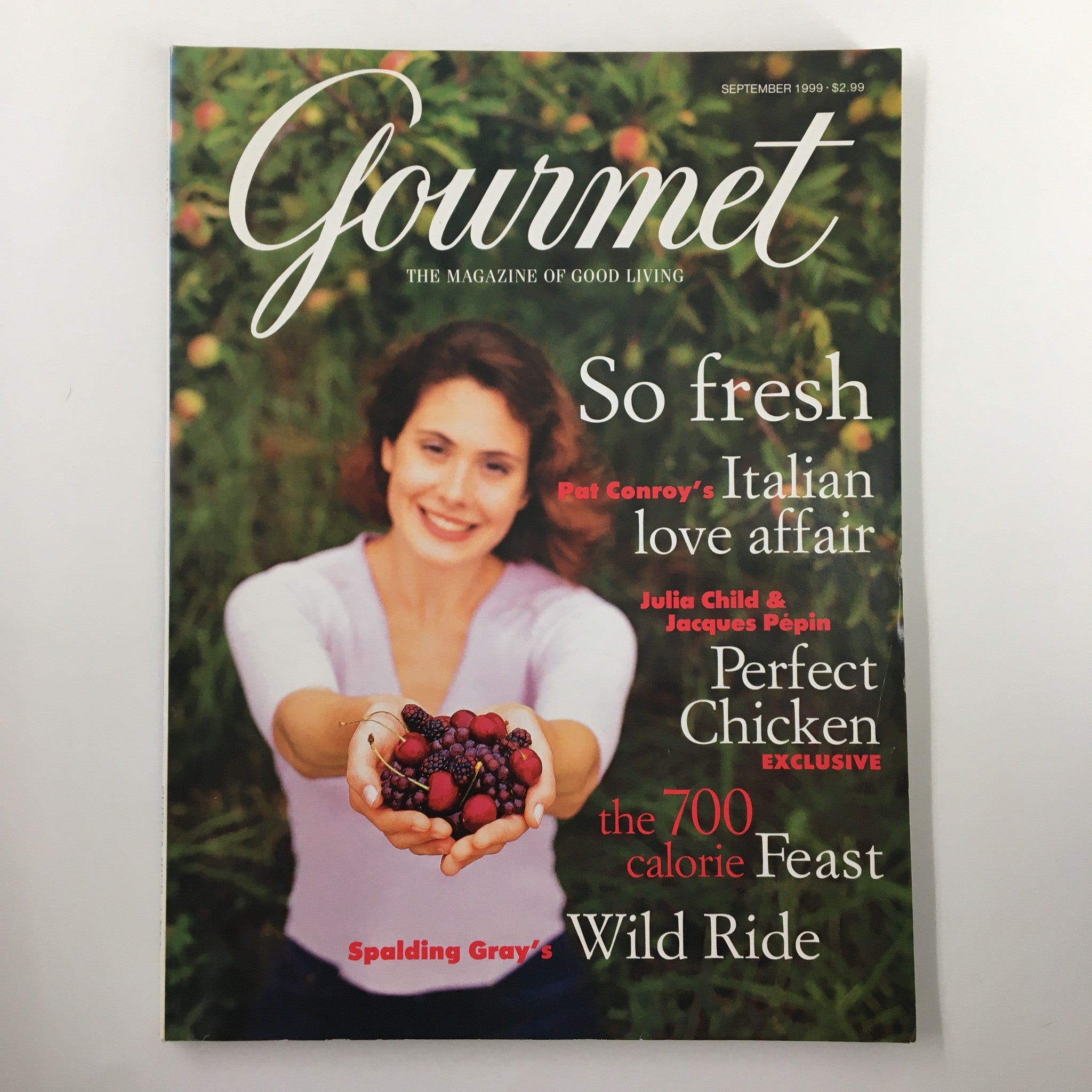 Cover of Gourmet Magazine September 1999 featuring the article 'Pat Conroy's Italian Love Affair.' The magazine showcases a woman holding fresh berries, highlighting themes of culinary exploration. Other featured articles include 'Perfect Chicken' by Julia Child & Jacques Pépin, and 'The 700 Calorie Feast,' capturing the essence of good living in the culinary world.