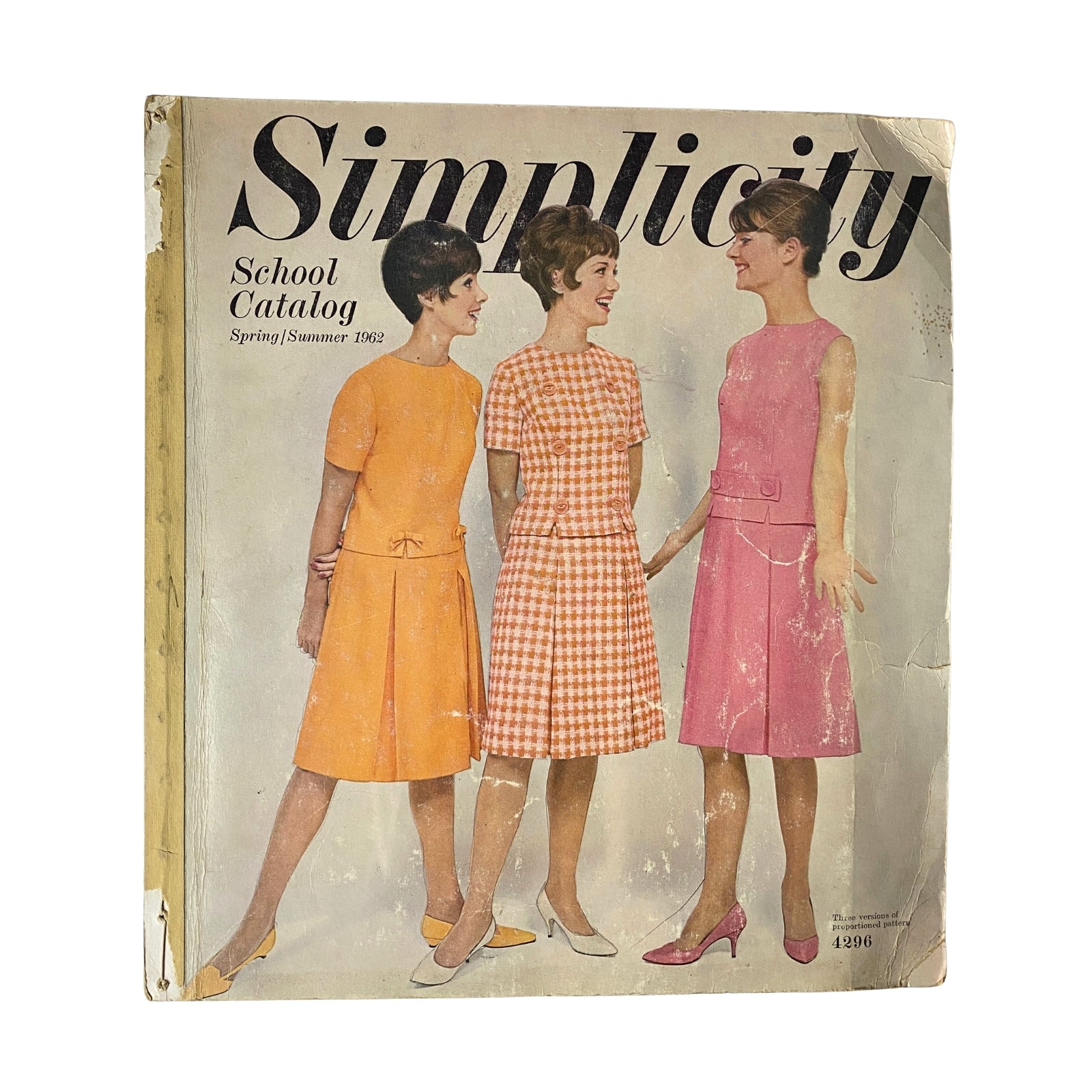 1962 Simplicity Spring Summer School Catalog featuring three models showcasing youth fashion dresses in vibrant colors, including an orange dress, a gingham-patterned dress, and a pink dress, ideal for sewing enthusiasts and vintage collectors.