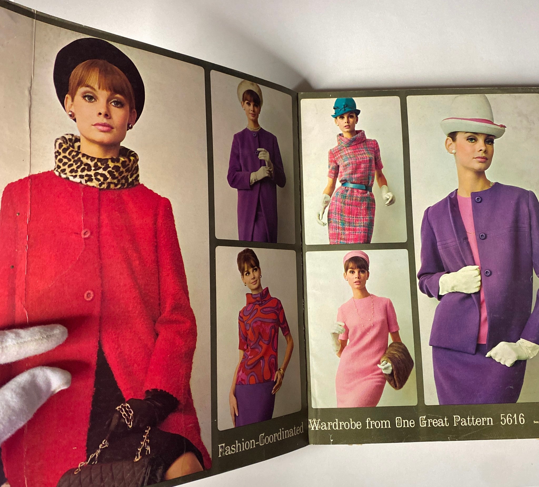 1964 October Simplicity Fall Catalog showcasing vintage fashion styles with a model wearing a red coat and various autumn outfits in a store counter display.
