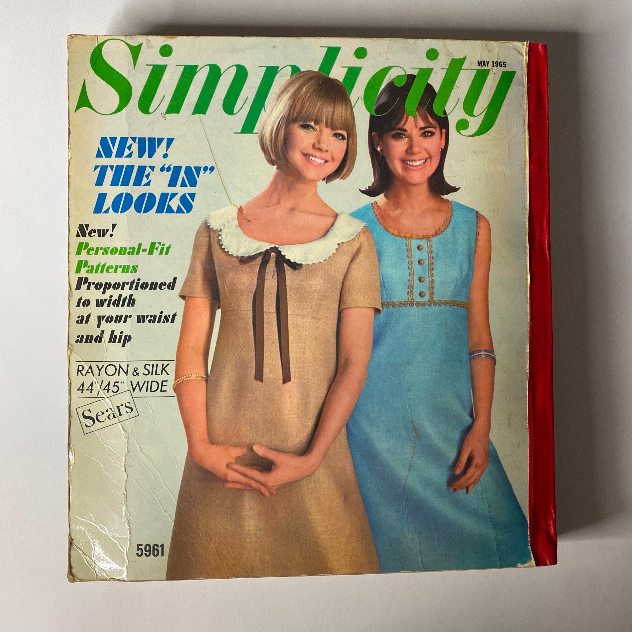 Cover of the 1965 May Simplicity Catalog showcasing vintage sewing patterns. Features two models wearing stylish dresses, highlighting Personal-Fit Patterns with detailed design elements. Ideal for fashion enthusiasts and collectors, it represents mid-century American style.