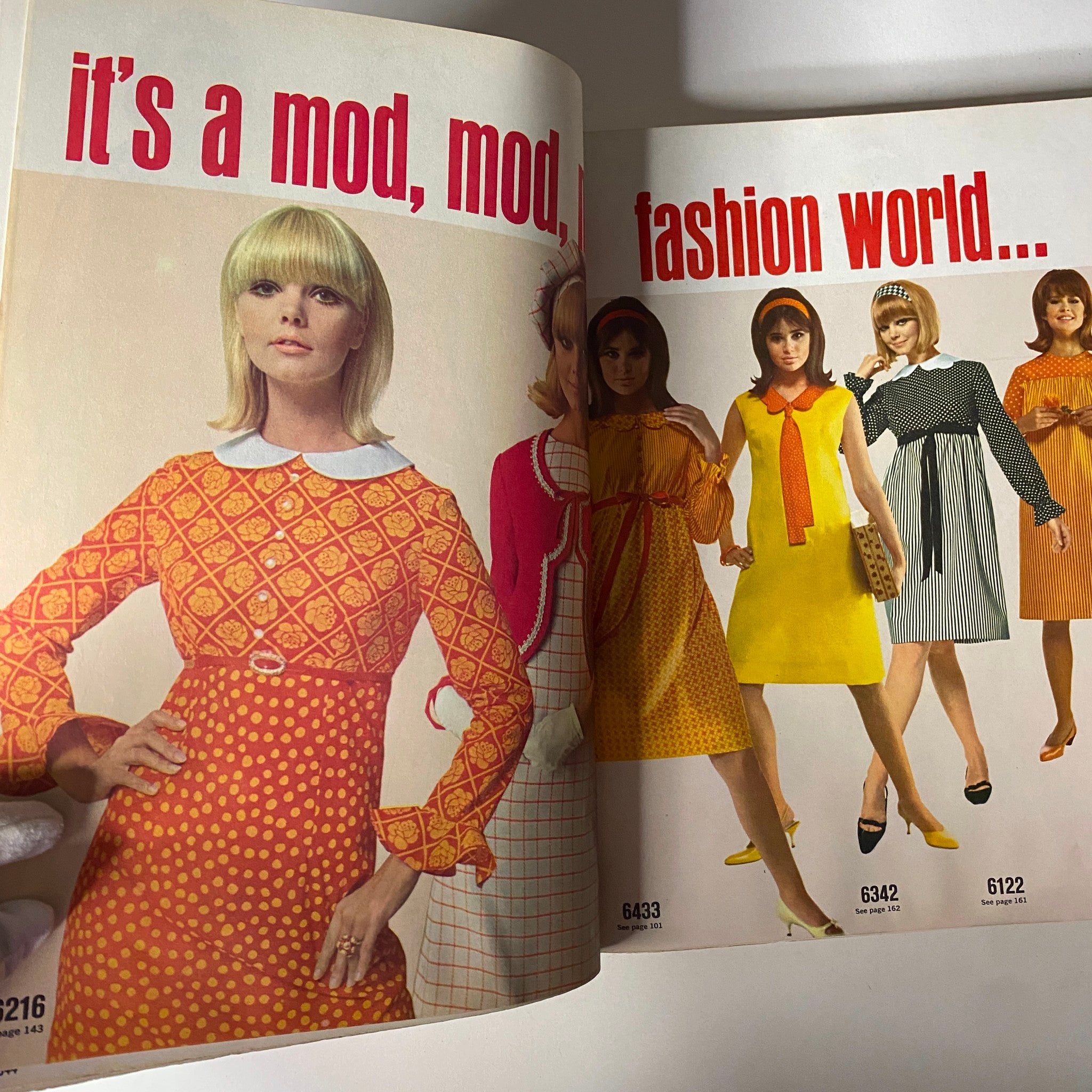 1966 May Simplicity Fashion Giant Catalog page titled 'It's a mod, mod, fashion world...' featuring vibrant 1960s dresses on models with retro hairstyles, highlighting the playful fashion of the era.
