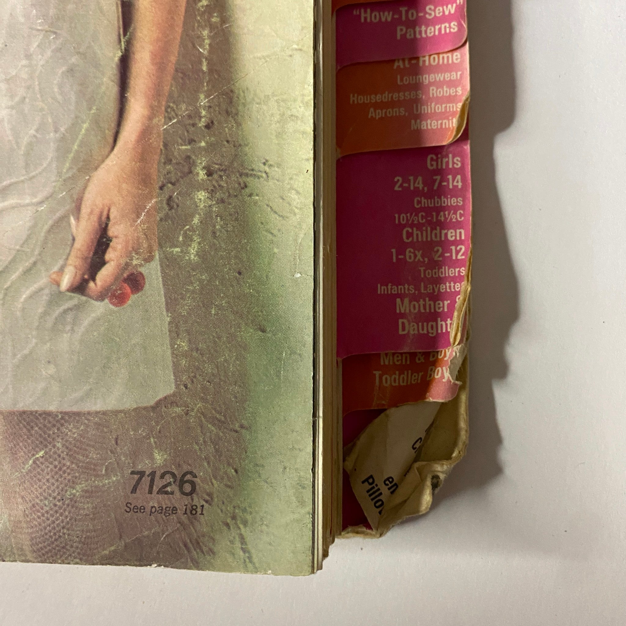 Close-up of the side of the 1967 June Simplicity Sewing Pattern Catalog displaying categorized patterns for girls and mothers, highlighting the diverse offerings of 1960s fashion.