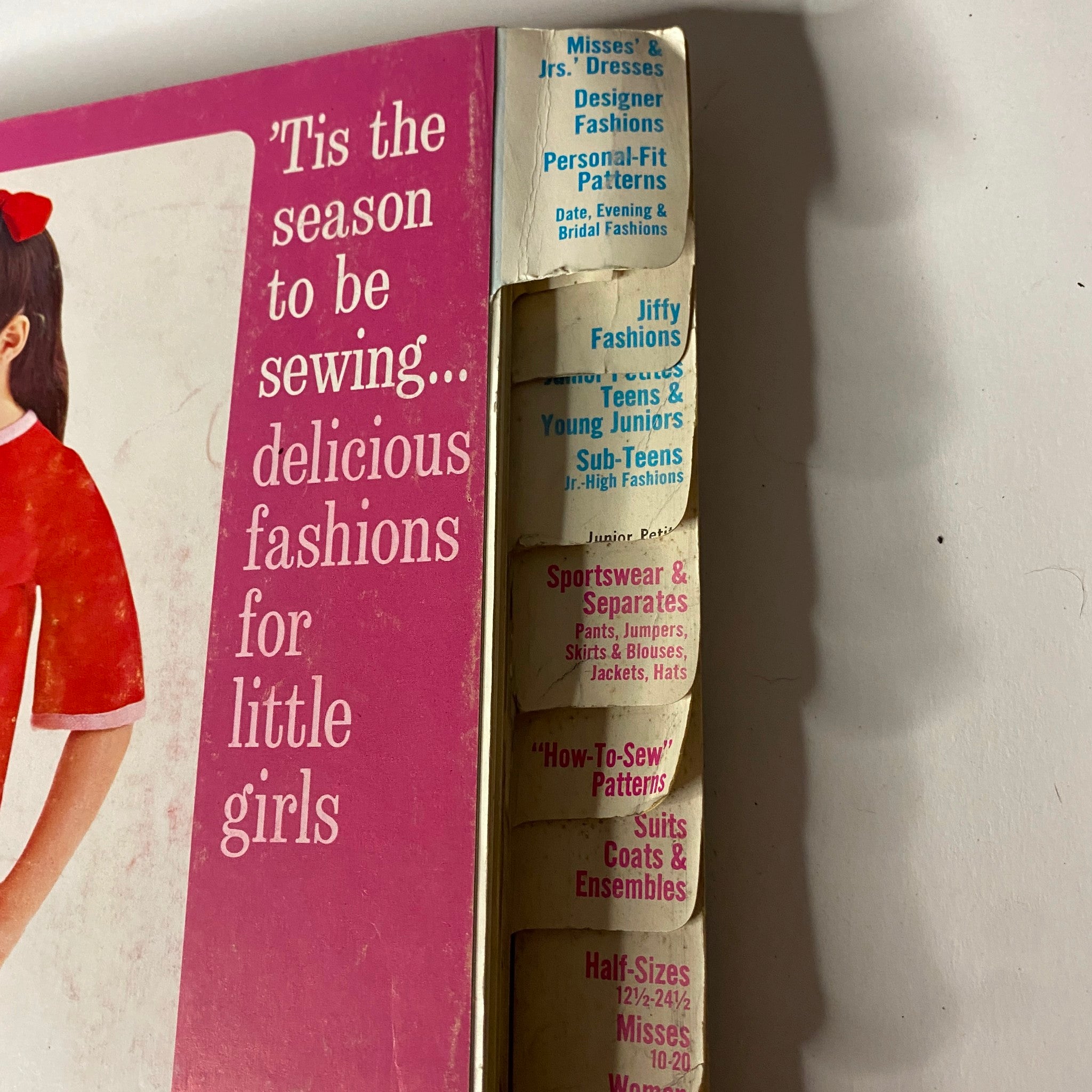 Side view of the 1967 January Simplicity Catalog, displaying the section titled 'Tis the Season to Be Sewing' with tabs for various categories including Misses' Dresses and Designer Fashions.
