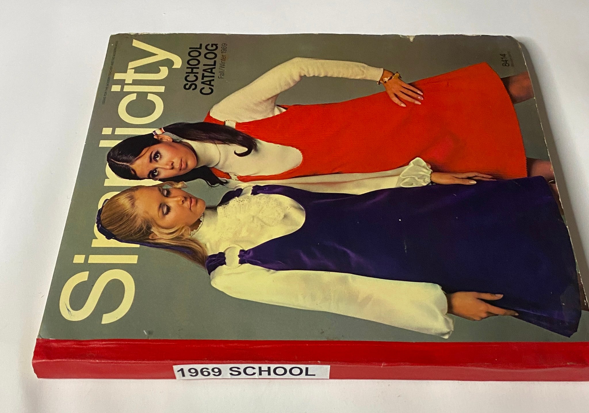 1969 Simplicity Fall and Winter School Catalog cover displaying two girls posed together, one in an orange dress and the other in a purple dress, with the catalog title prominently featured.