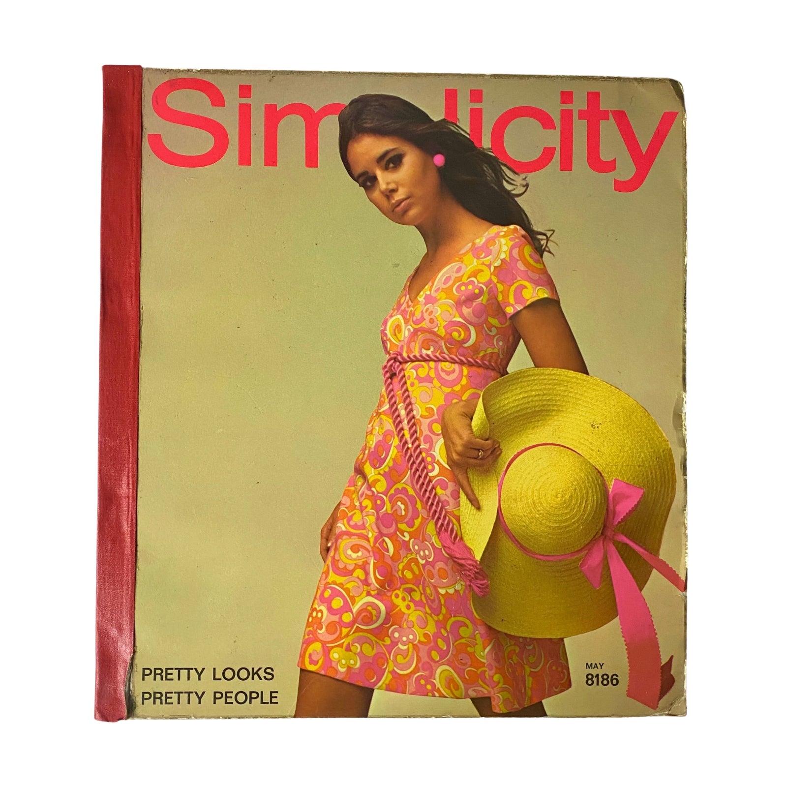 Cover of the 1969 May Simplicity Catalog showcasing a model in a colorful floral dress and wide-brimmed hat, emphasizing vintage fashion design.