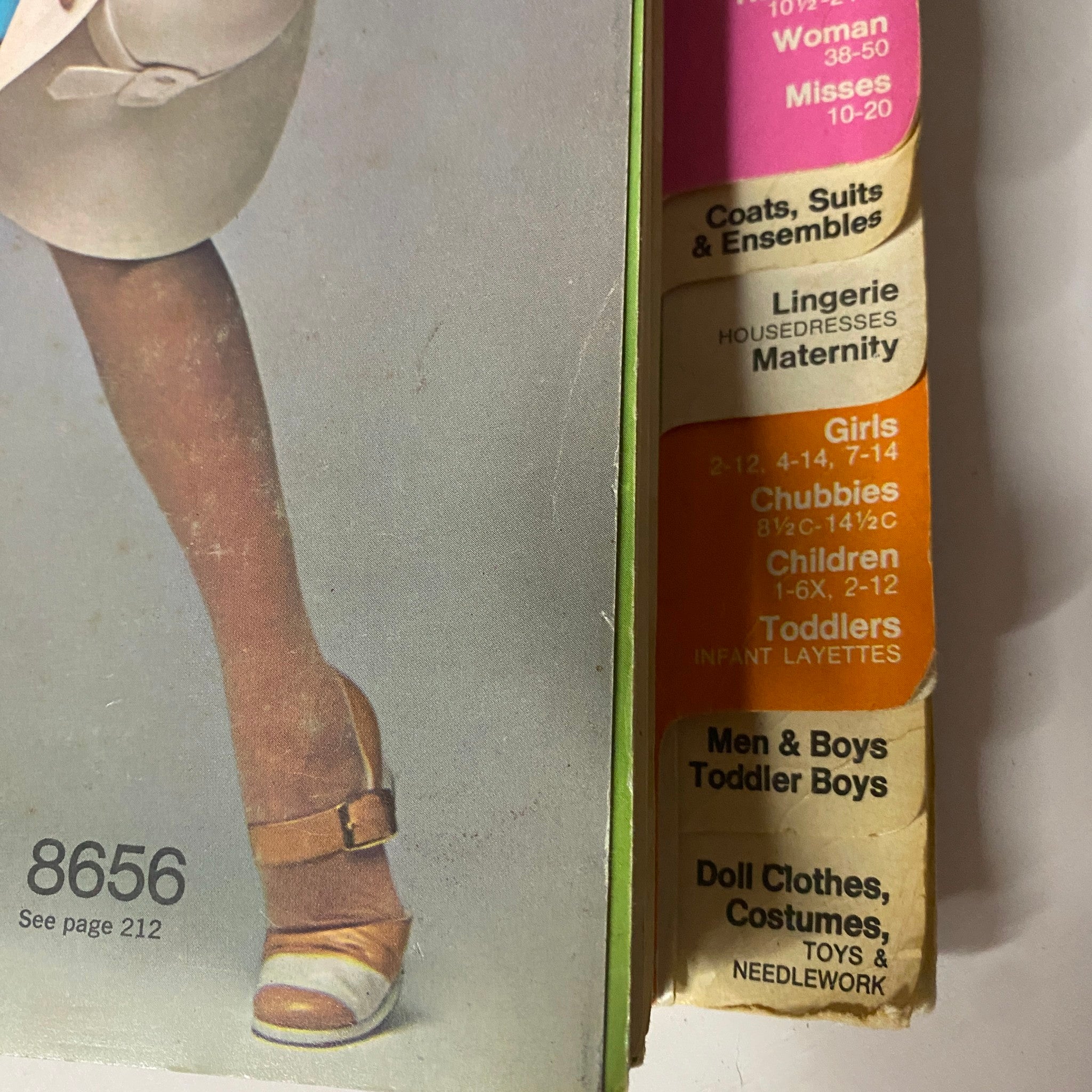 Detailed capture of the spine of the 1970 March Simplicity Spring Catalog displaying different sections for children's and women's clothing patterns, enticing pattern collectors and sewers.