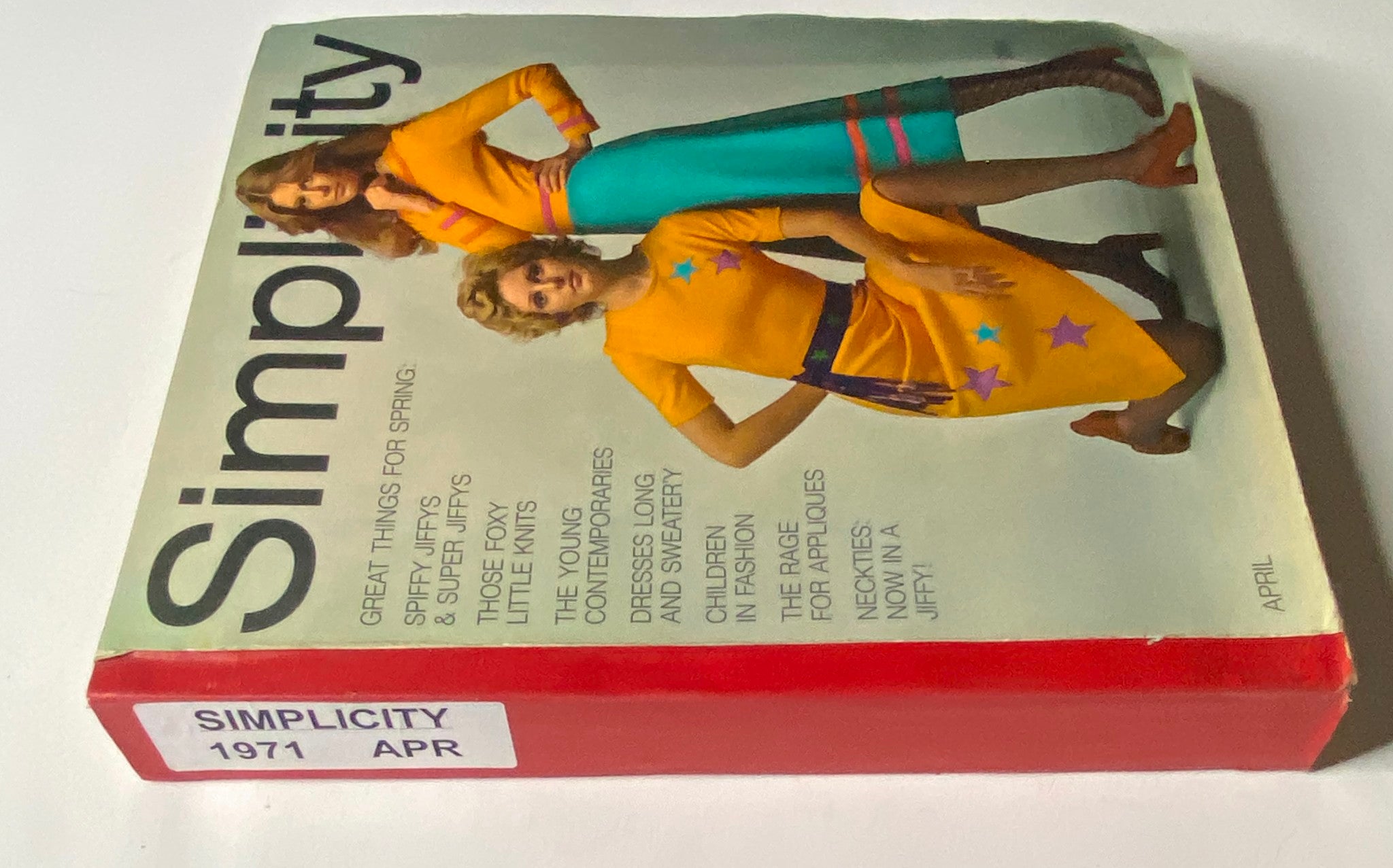 Side view of the 1971 April Simplicity Spring Catalog depicting playful fashion designs with models in bright outfits, highlighting the creative styles of the 1970s.