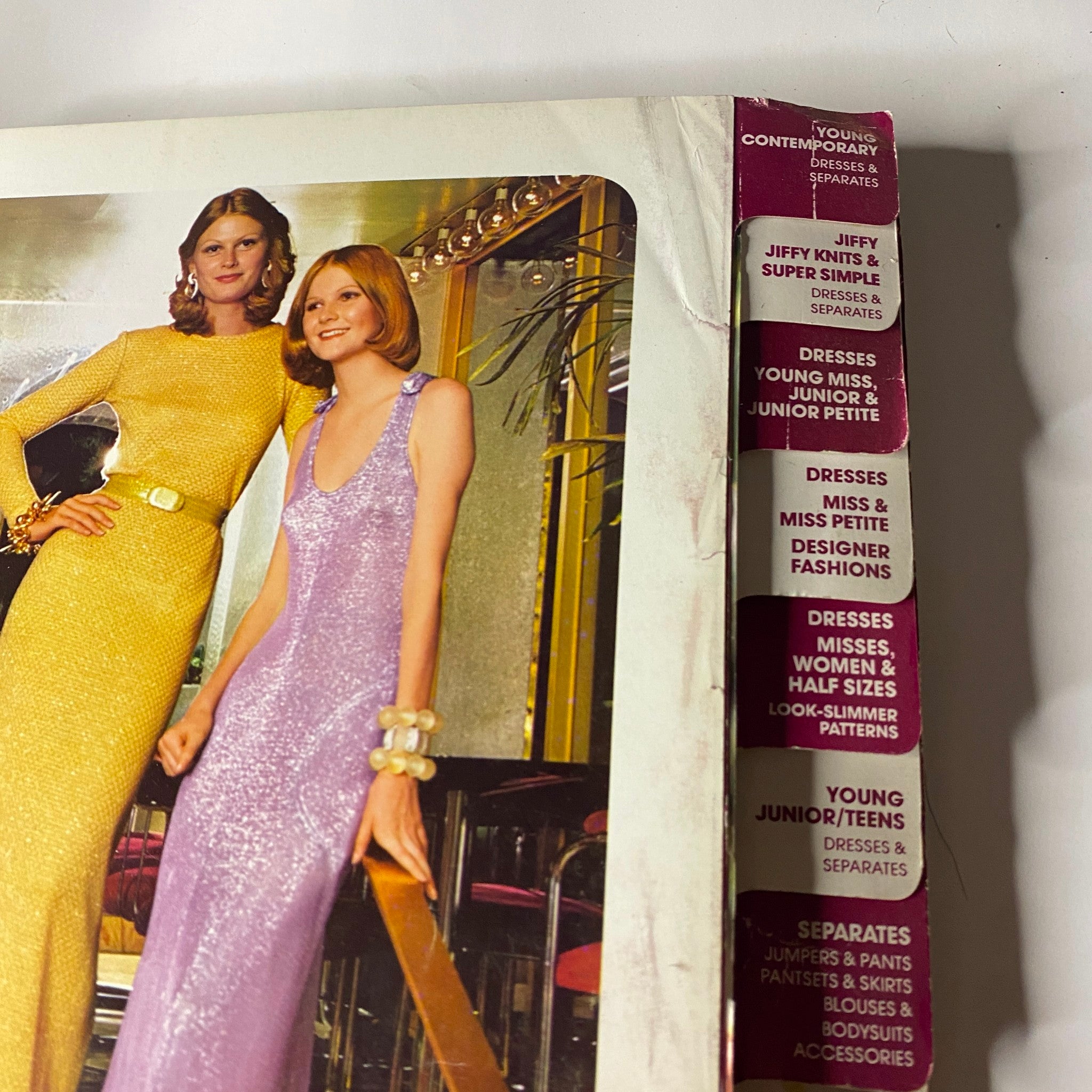 1972 December Simplicity Catalog Sewing Pattern featuring models in fashionable evening gowns; showcases vibrant colors and styles for young contemporary fashion.