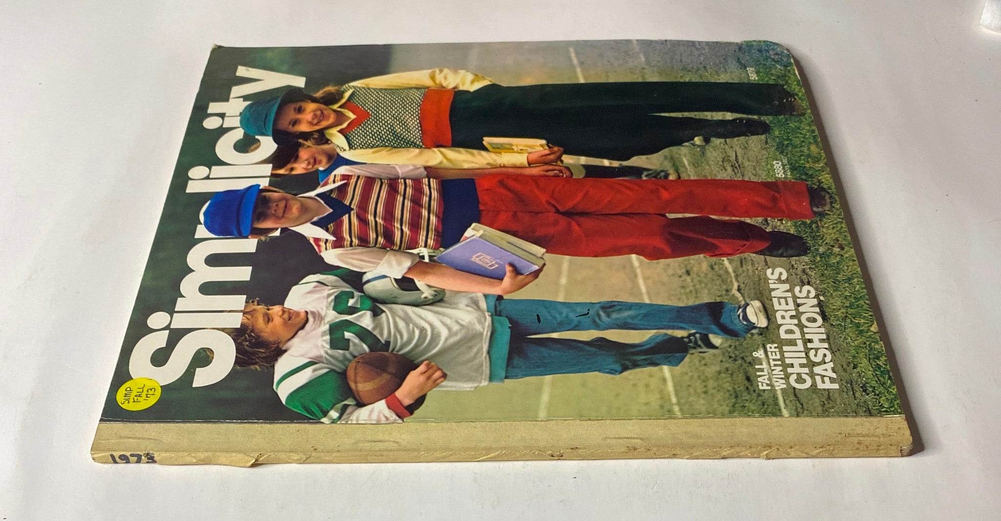 Side view of the 1973 Simplicity Fall and Winter Catalog displaying children’s fashions, emphasizing colorful outfits and accessories.
