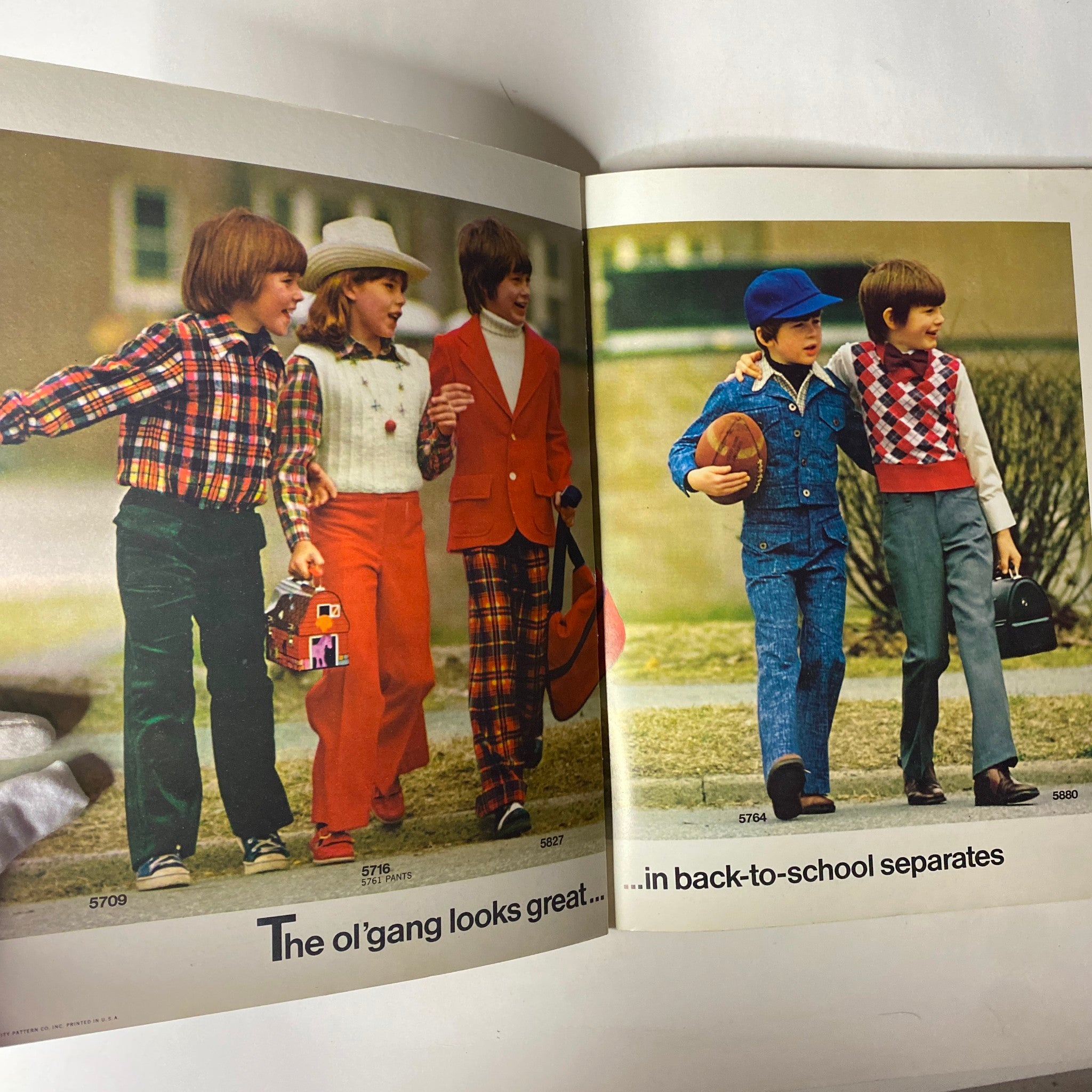 Inside spread of the 1973 Simplicity Fall and Winter Catalog, depicting children wearing seasonal outfits for play and schooling.