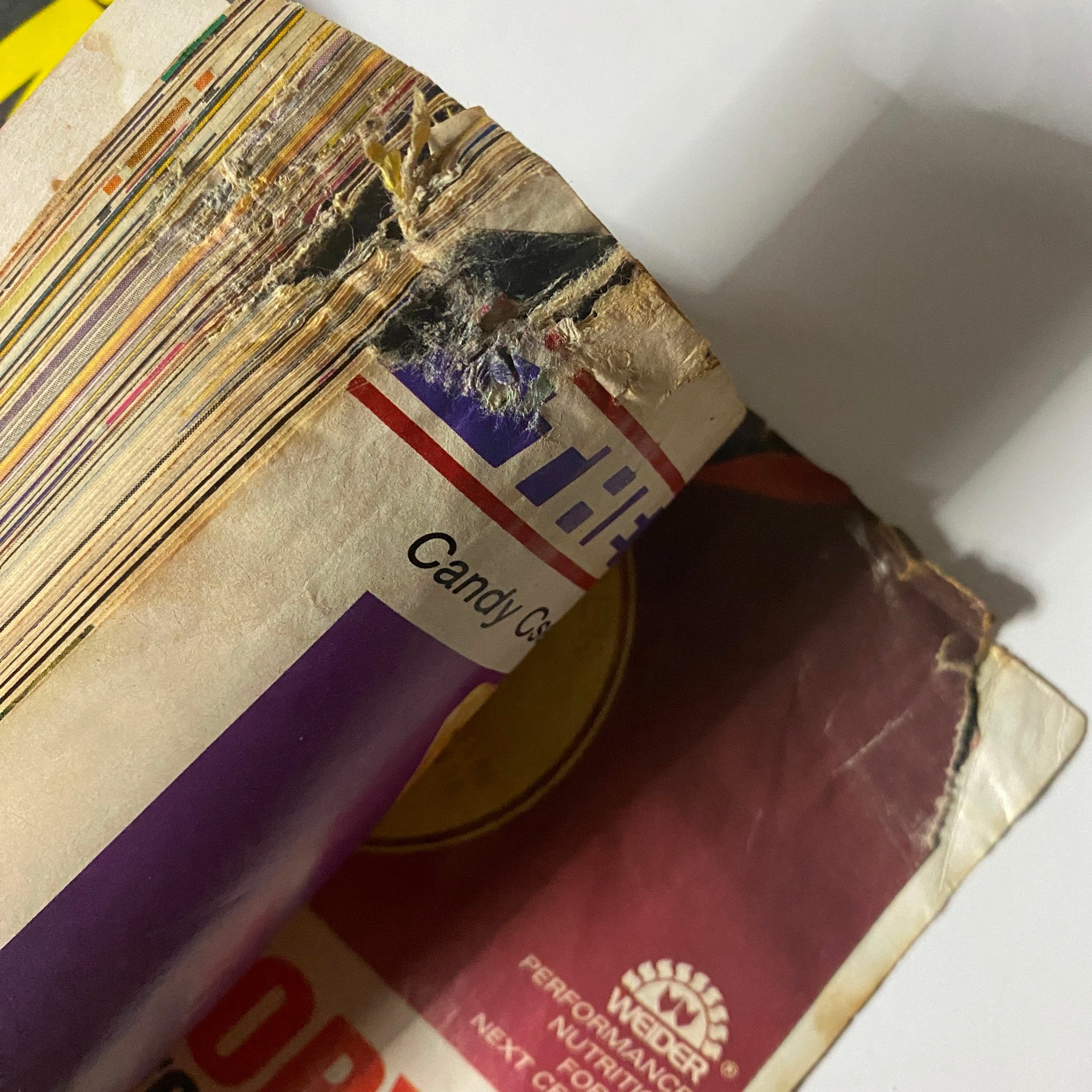 Detailed view of the damaged spine of Muscle & Fitness Magazine September 1989, showcasing its vintage characteristics.