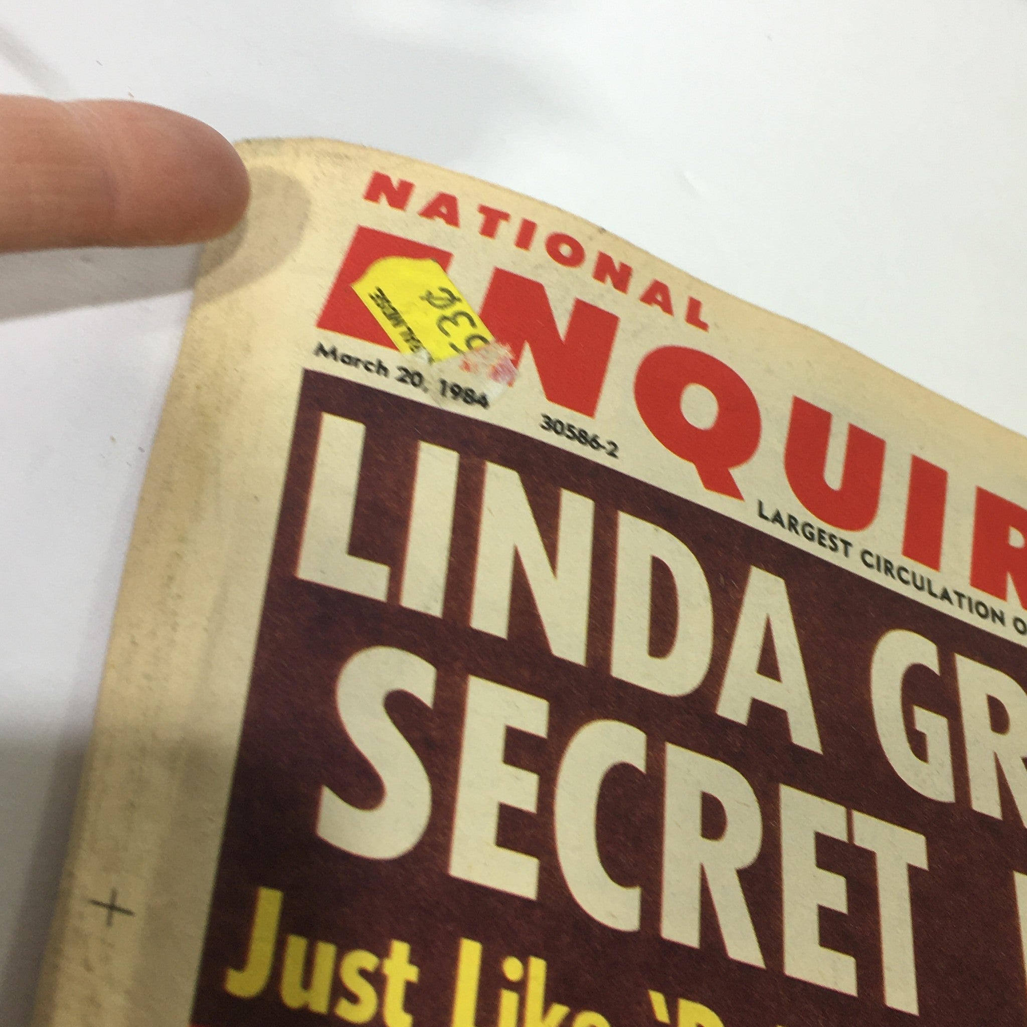 Detailed view of the top corner of the National Enquirer Magazine dated March 20, 1984, showcasing its vintage price sticker and publication date.