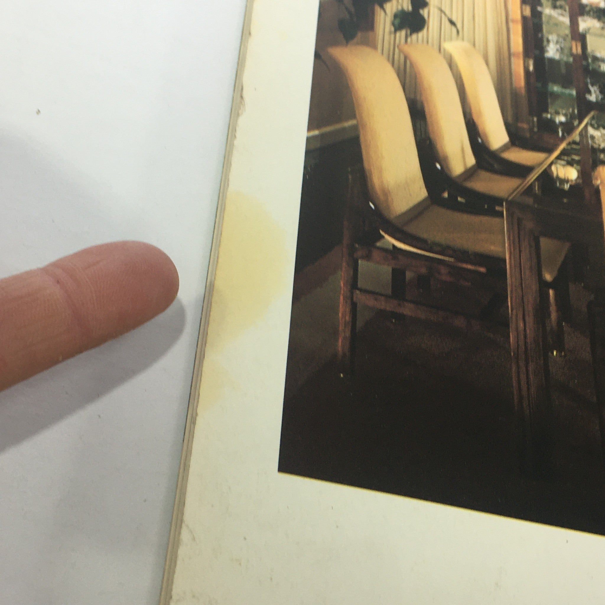Close-up of a water-stained edge of a page with a dining room image, noted in VTG Geo Magazine: April 1980 Vol. 2 - A New View Of Our World / Daytona Beach.