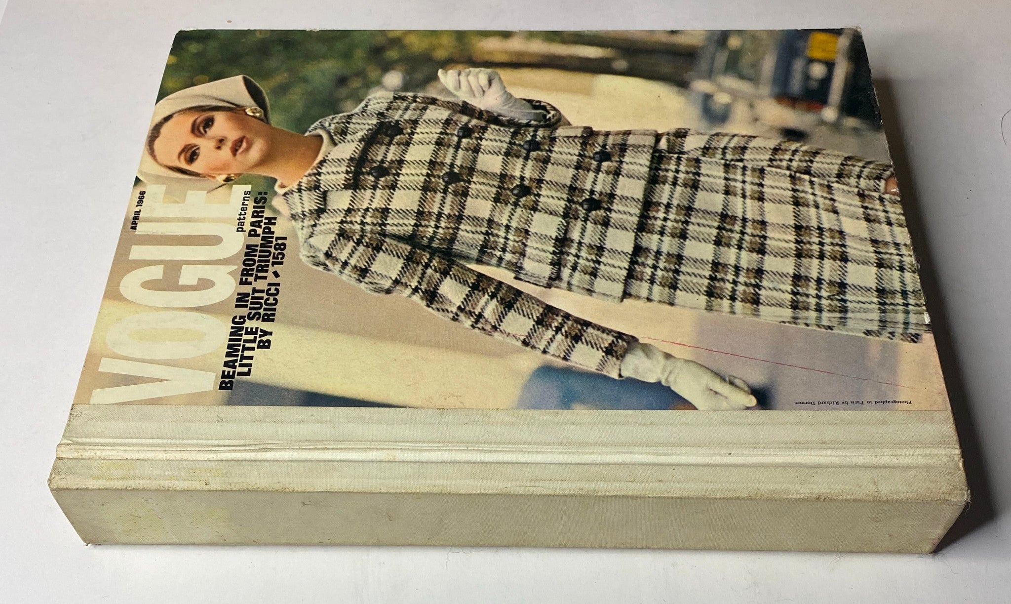 1966 Vogue Patterns April Catalog cover showing the model in a classic checked suit, highlighting the fashion trends of the era.