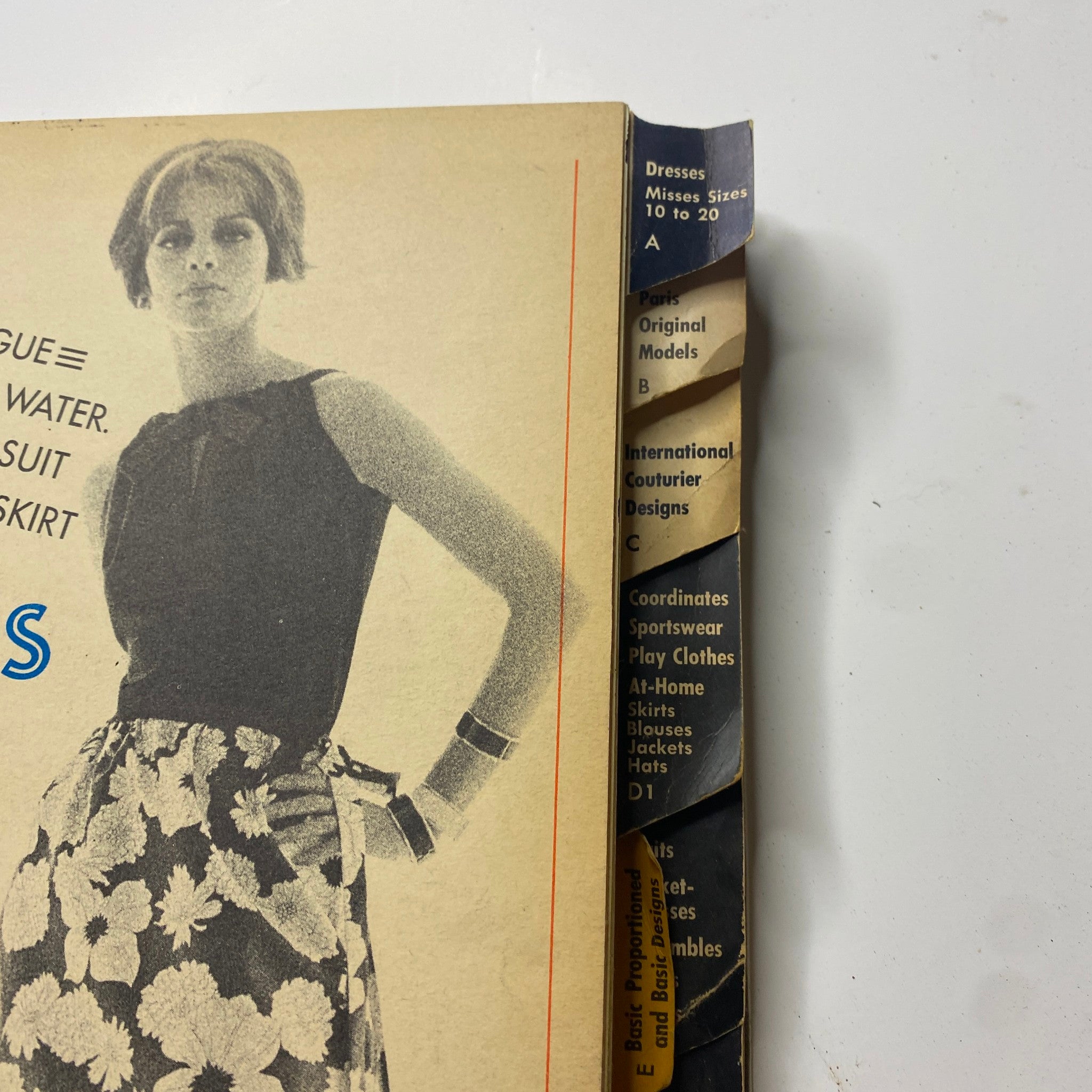 Close-up of the side of the Vogue Patterns June 1964 Catalog, highlighting text on fashion categories and designs from the era.