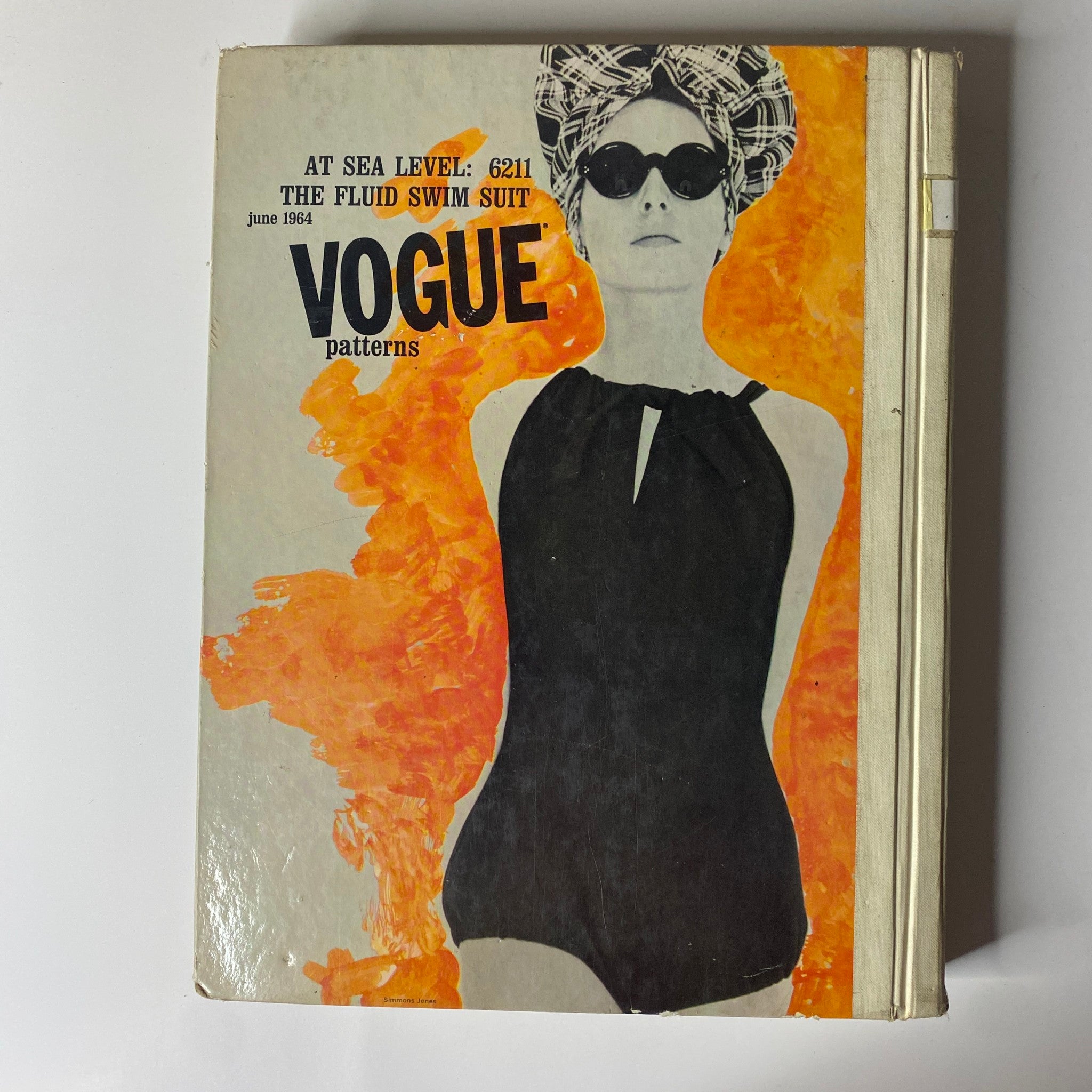Cover of the Vogue Patterns June 1964 Catalog featuring a classic swimwear design, Vogue 6211, emphasized by a chic model and vibrant graphics.