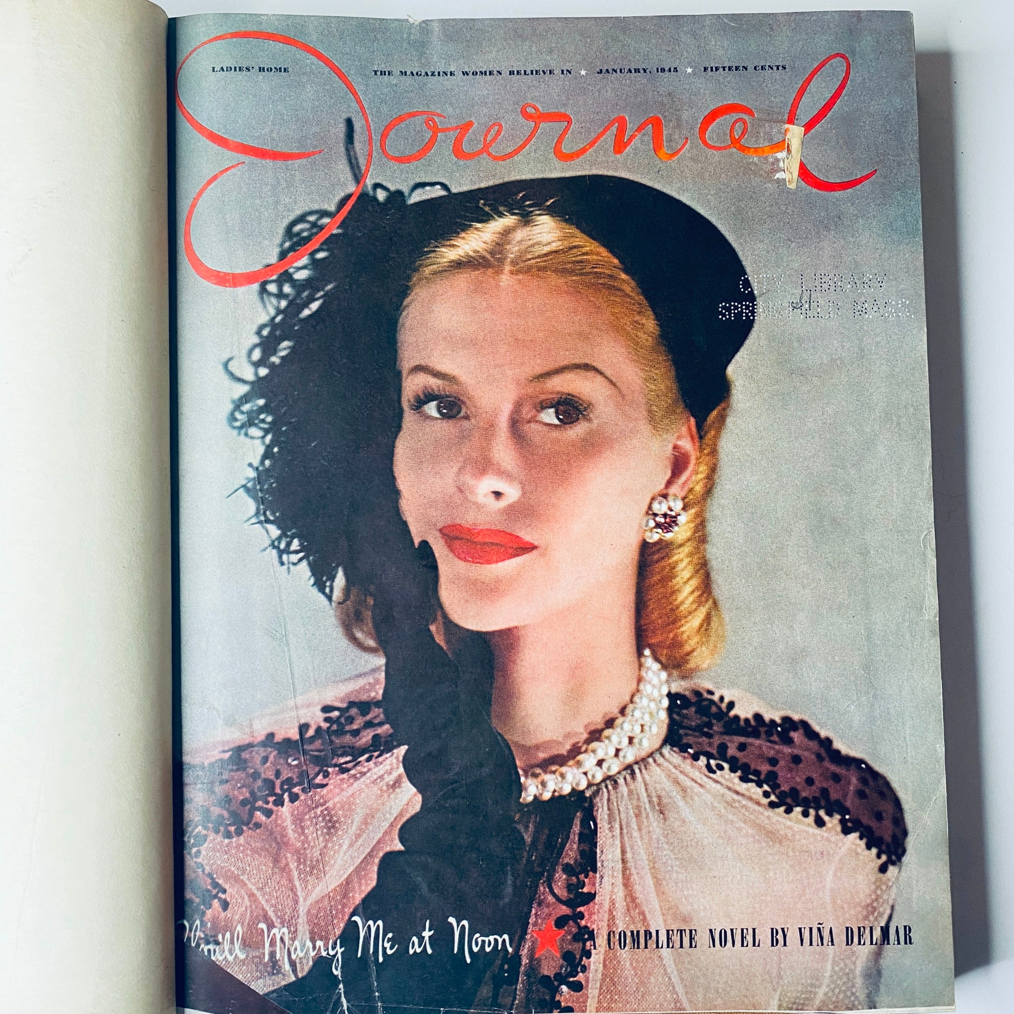 Cover of Ladies' Home Journal January 1945 featuring a woman in a glamorous outfit with a feathered hat and pearl necklace, presenting the title 'Will Marry Me at Noon' - part of the 1945 library bound magazine collection.
