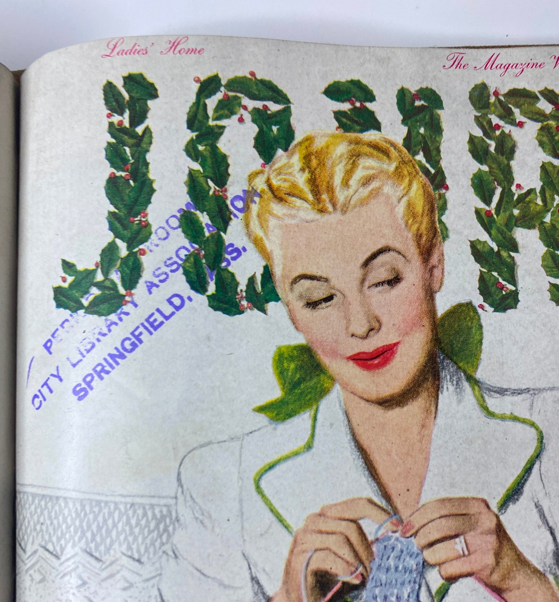 Close-up of the Ladies' Home Journal title with holiday-themed decorations, featuring a woman knitting, from the 1945 collection.