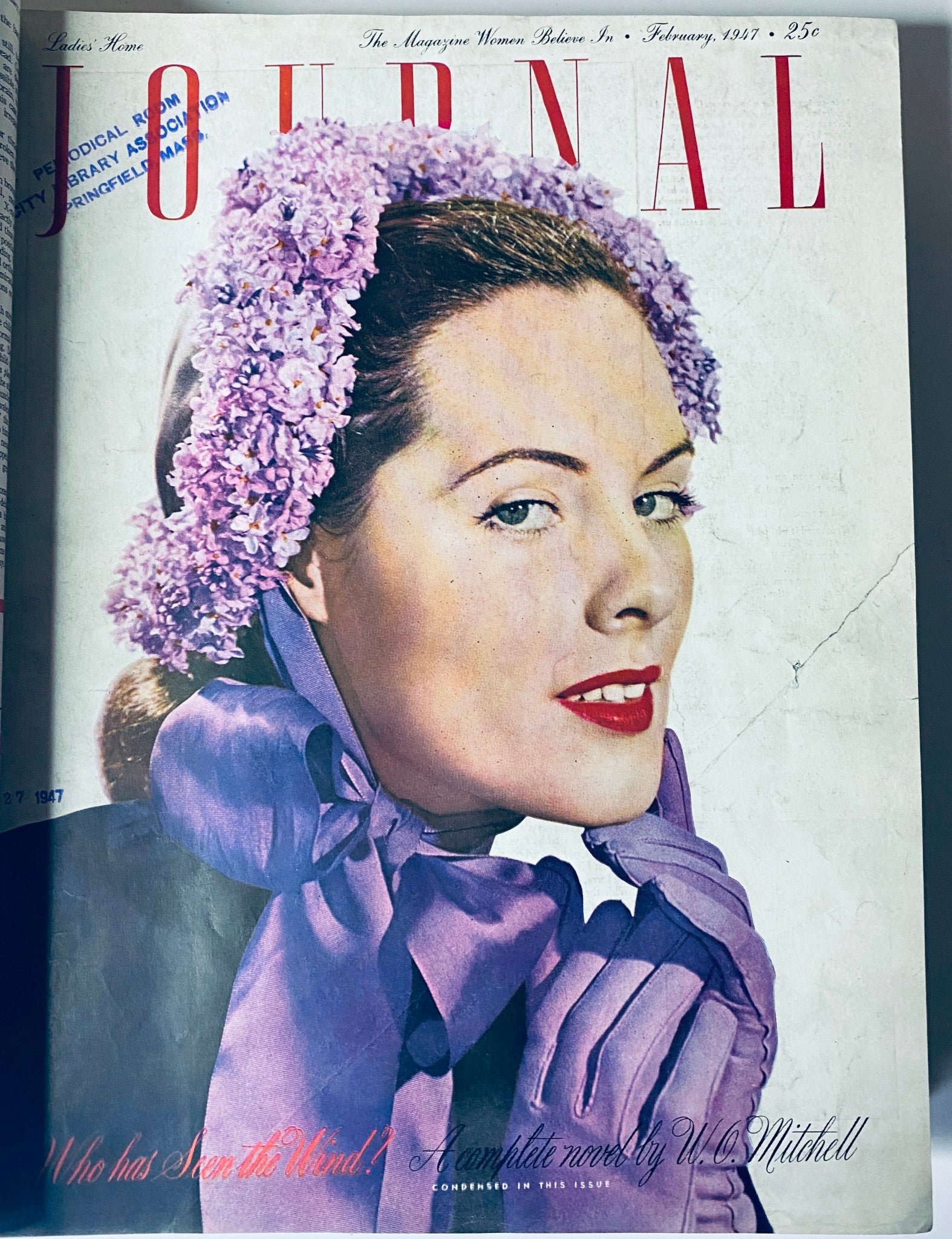 February 1947 cover of Ladies' Home Journal, showcasing a woman adorned in lilacs with a stylish expression.