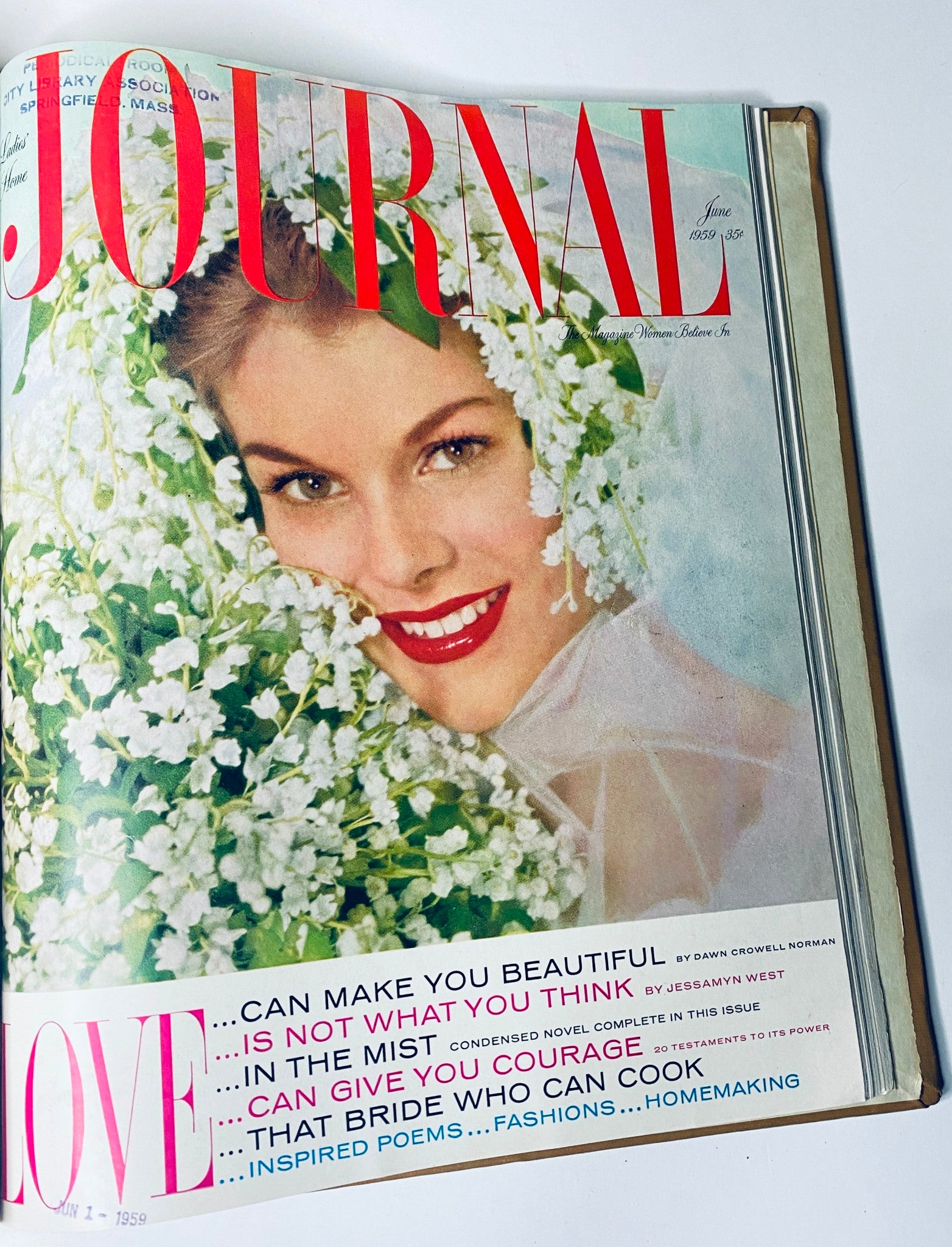 Cover of Ladies' Home Journal, June 1959 issue, featuring a smiling woman surrounded by flowers, representing beauty and lifestyle advice from the 1950s.