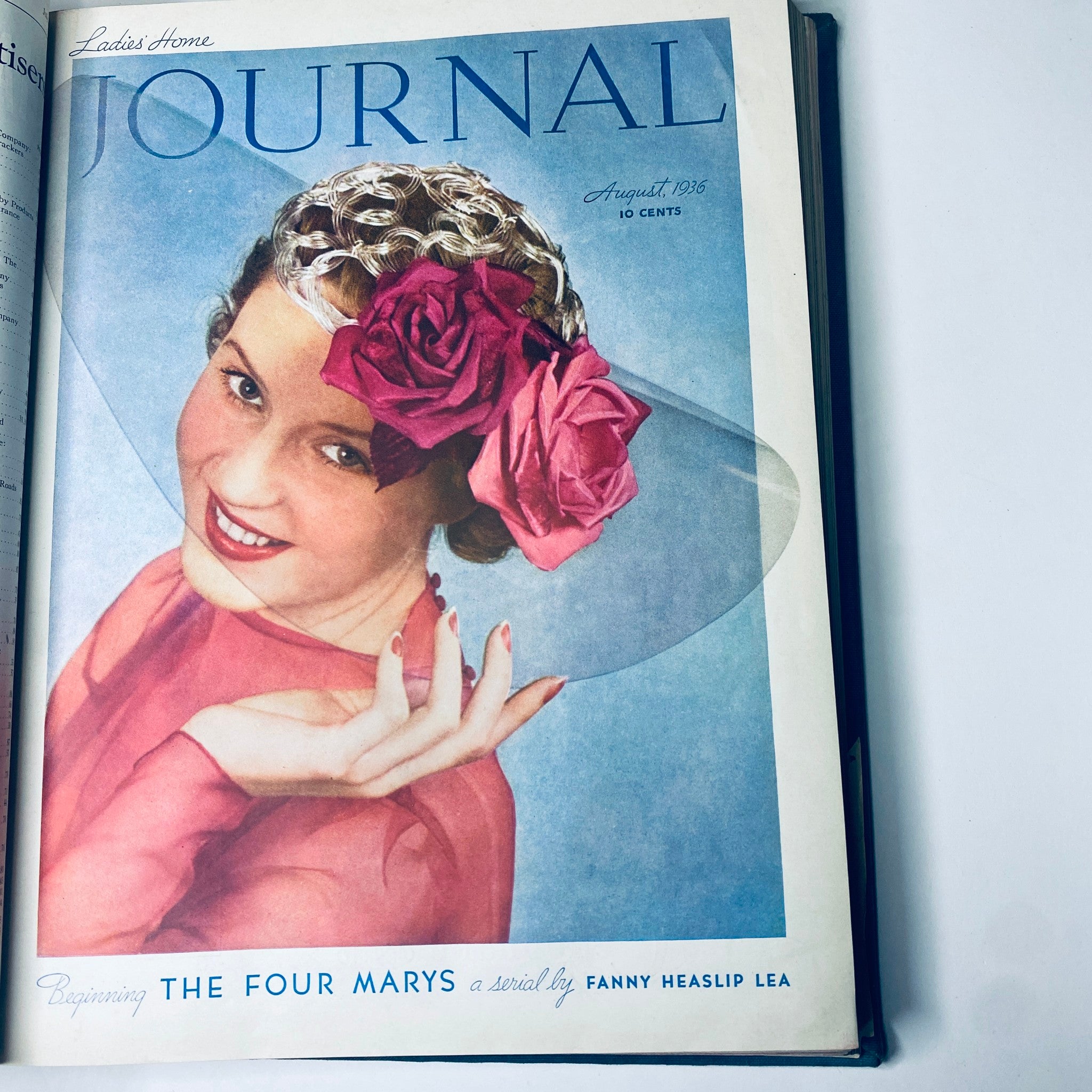 Cover page of the August 1936 Ladies' Home Journal magazine featuring a smiling woman with roses in her hair and a stylish outfit, highlighting the fashion trends of the era.