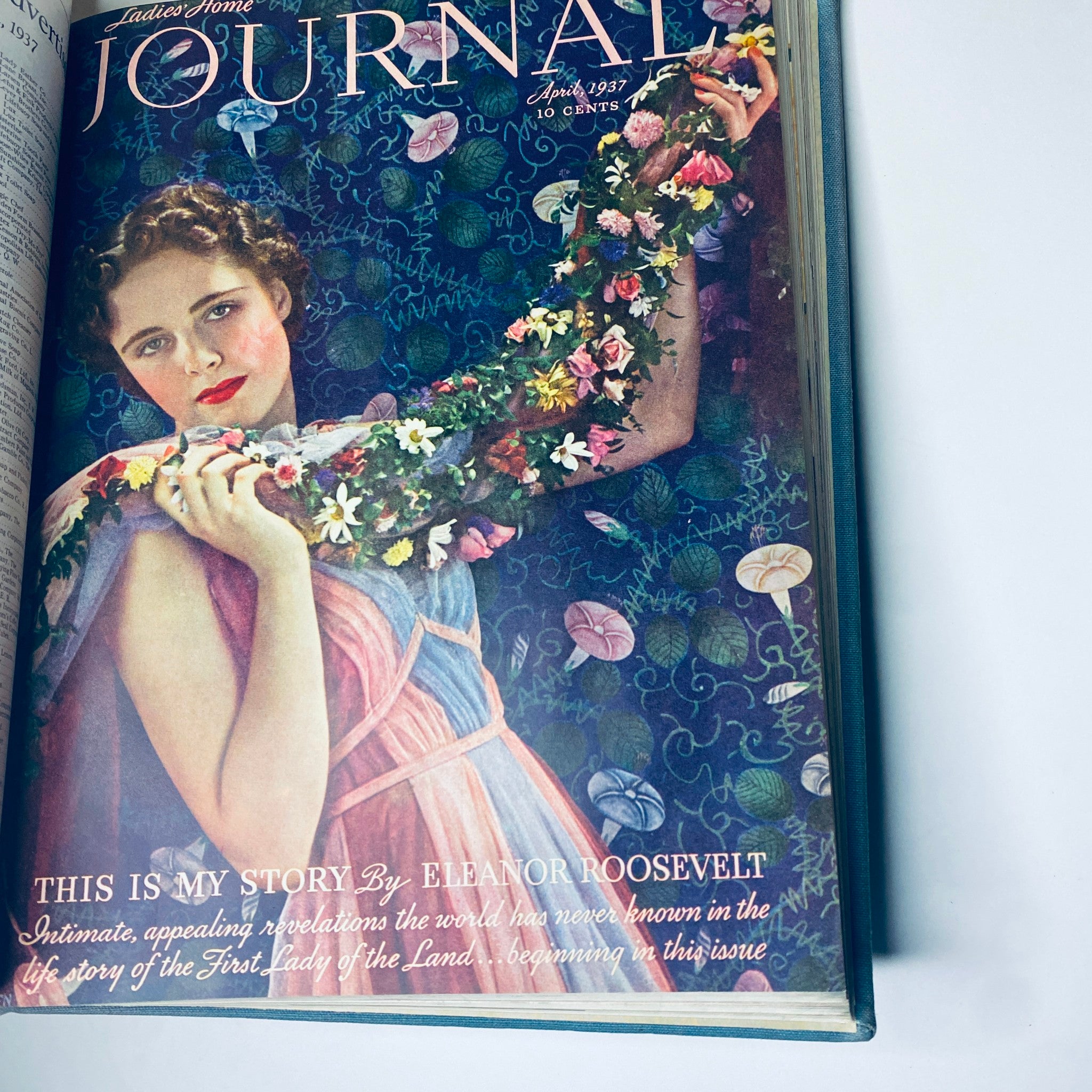 Cover of Ladies' Home Journal April 1937 depicting a young woman gracefully adorned with flowers, highlighting the artistic illustration style of the era.