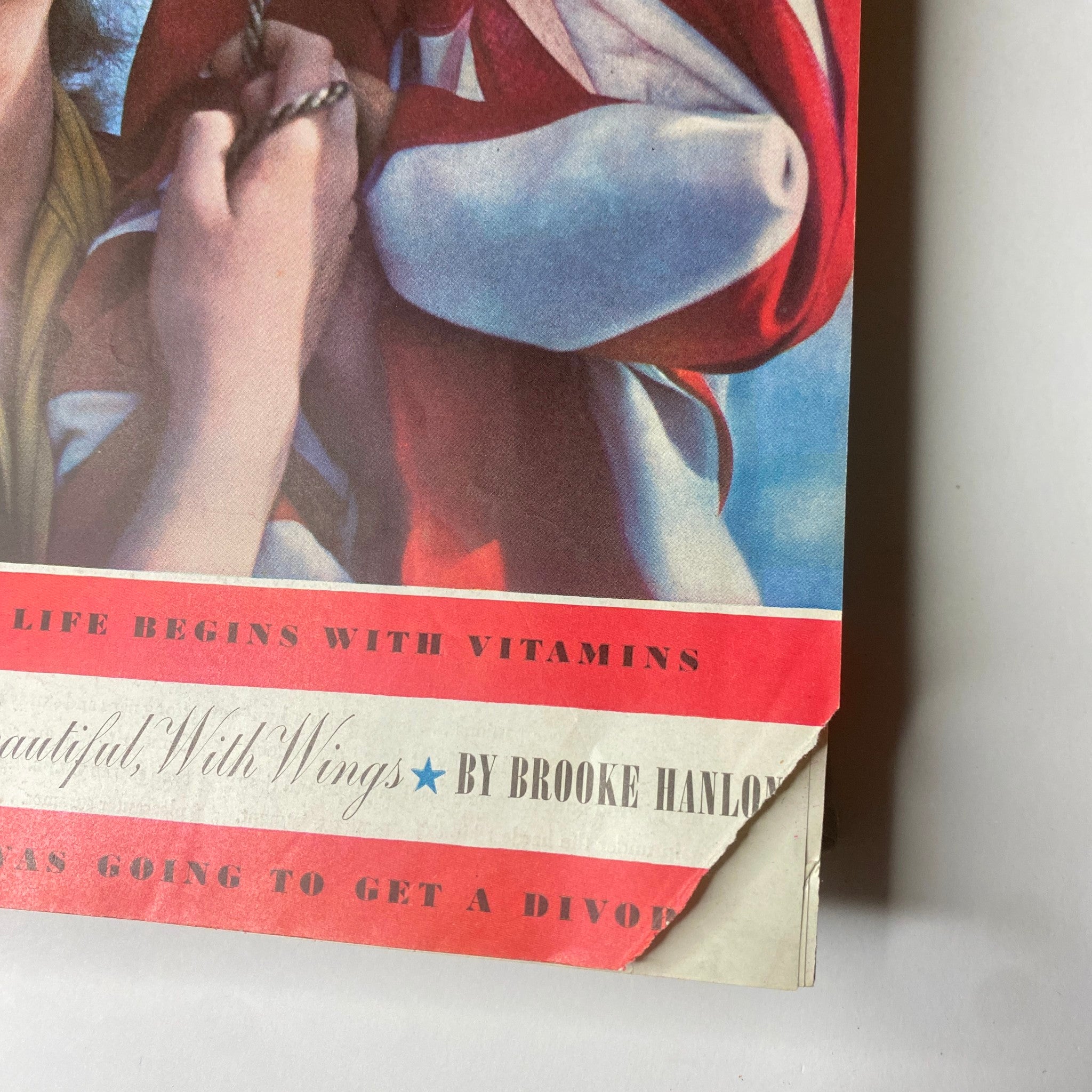 Detail of Ladies' Home Journal July 1941 cover showcasing the vibrant red and blue typography along with a woman's smiling face and American flag backdrop.