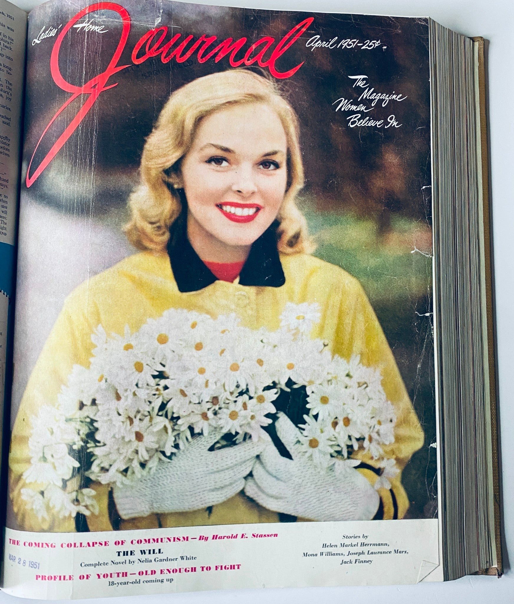 Cover of Ladies' Home Journal April 1951 magazine featuring a smiling woman in a yellow coat holding white flowers. This image highlights the nostalgic charm of the 1950s era.