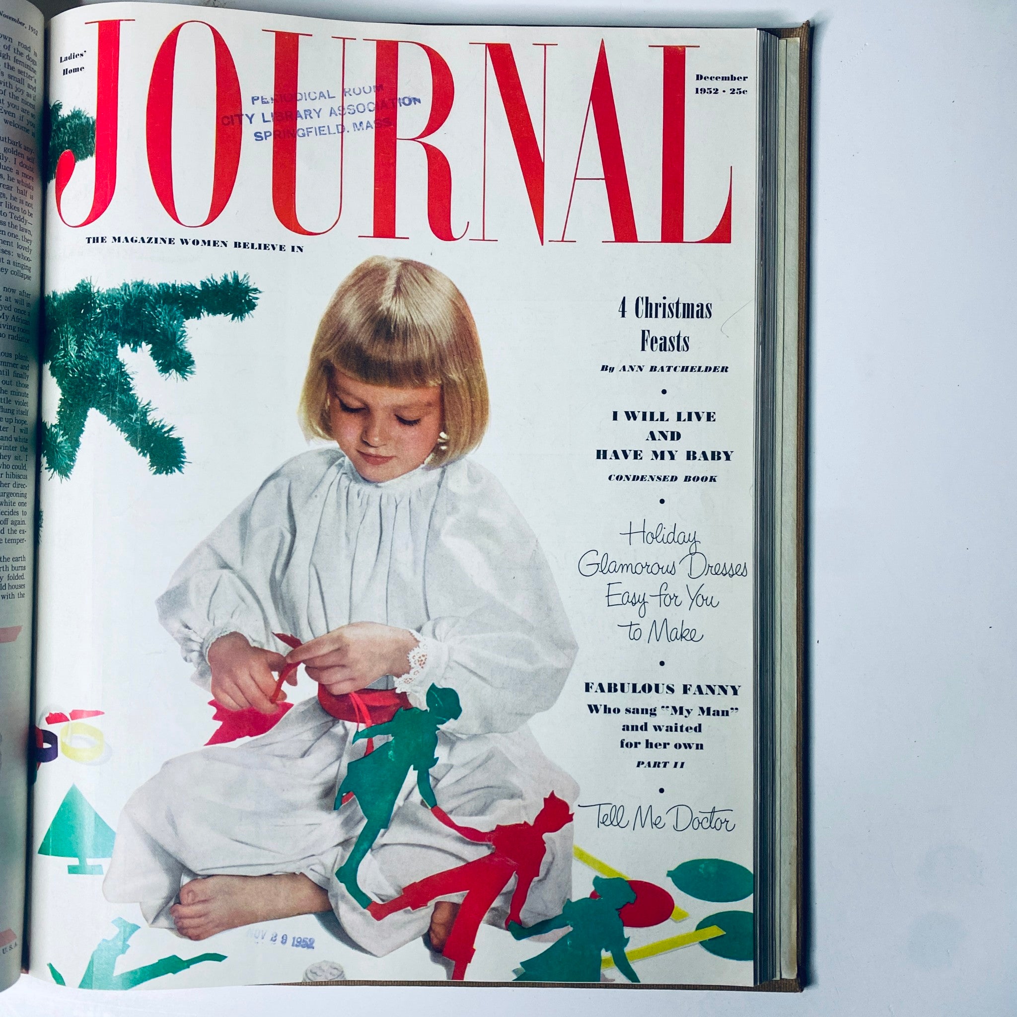 Cover of Ladies' Home Journal December 1952 featuring a young girl crafting holiday decorations, emphasizing family traditions and festive spirit.