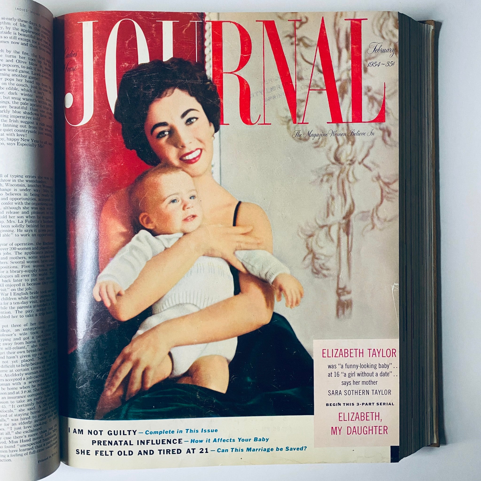 Ladies' Home Journal February 1954 cover with Elizabeth Taylor and her baby showcasing a vintage aesthetic.