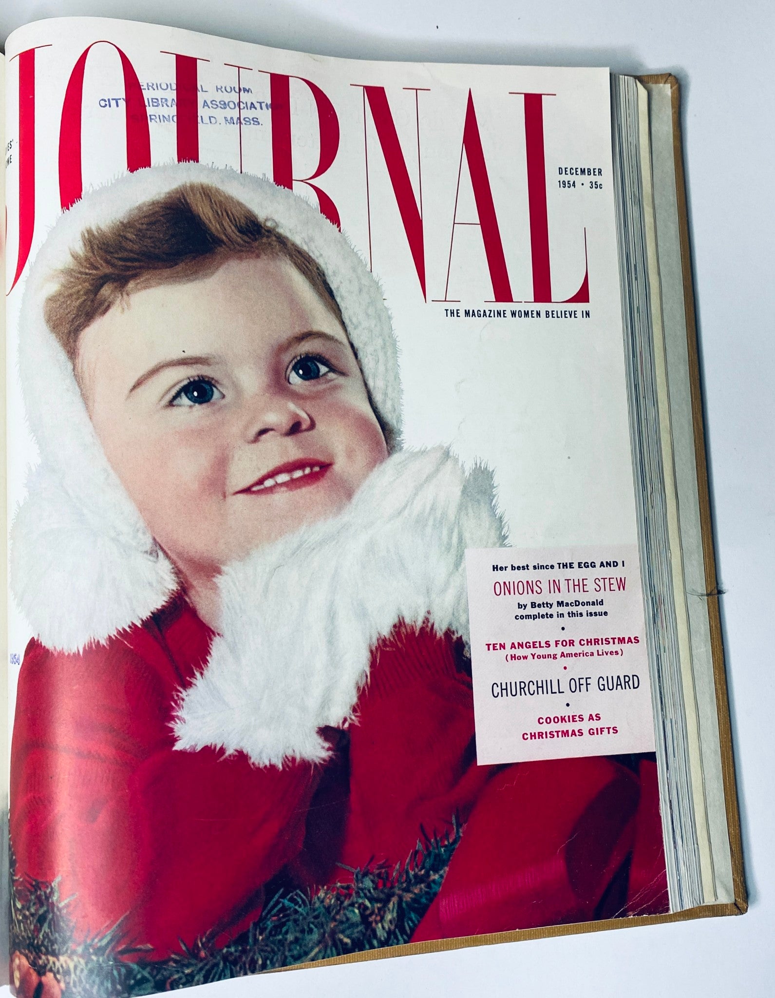 Cover image of the Ladies' Home Journal Bound Magazine for December 1954 depicting a smiling child dressed in a festive red outfit with white fur trim. This issue highlights Christmas themes and holiday recipes.