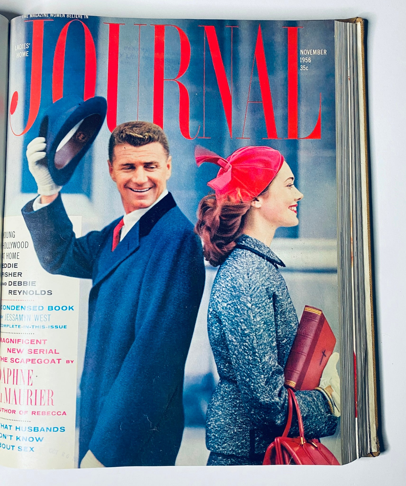 Cover of Ladies' Home Journal November 1956 featuring a smiling couple, with the male figure tipping his hat, exemplifying 1950s style and lifestyle.