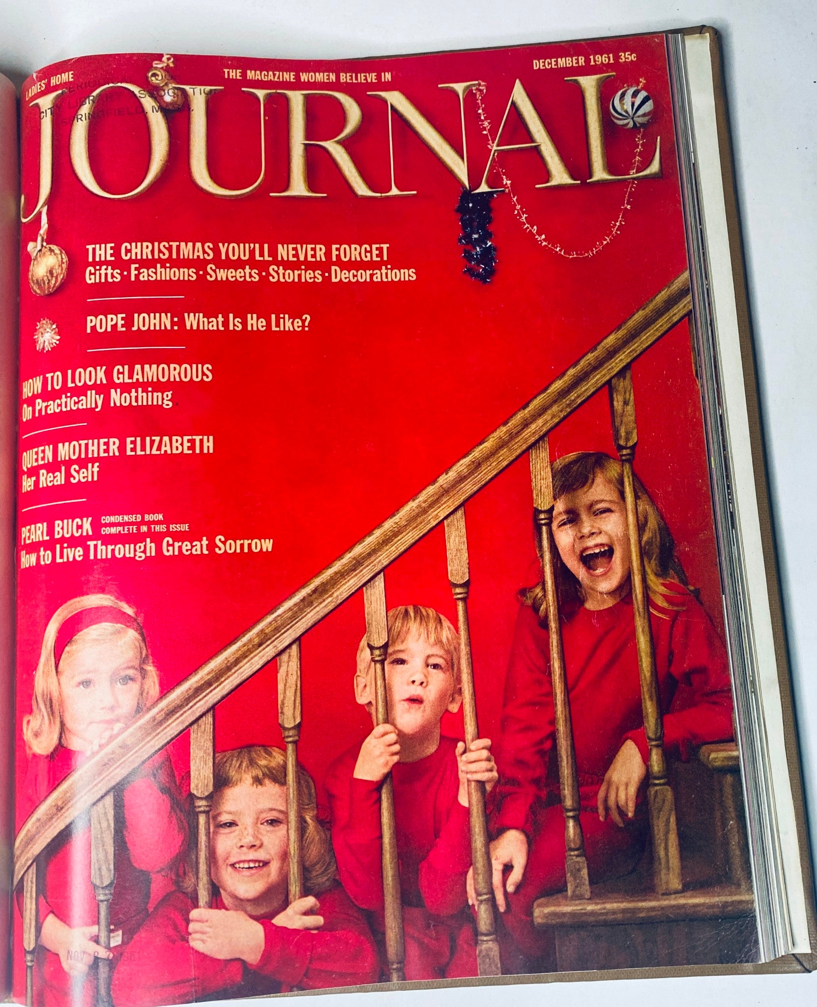 Cover of the Ladies' Home Journal magazine for December 1961, featuring children on stairs, showcasing holiday themes and festive decorations, part of the bound magazine set for 1961.