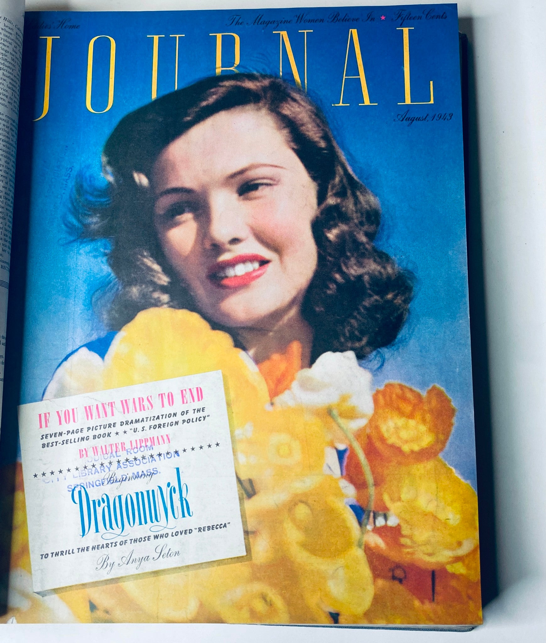 Cover of Ladies' Home Journal, August 1943 edition, showcasing a woman smiling while holding flowers, promoting 'Dragonwyck' by Anya Seaton.