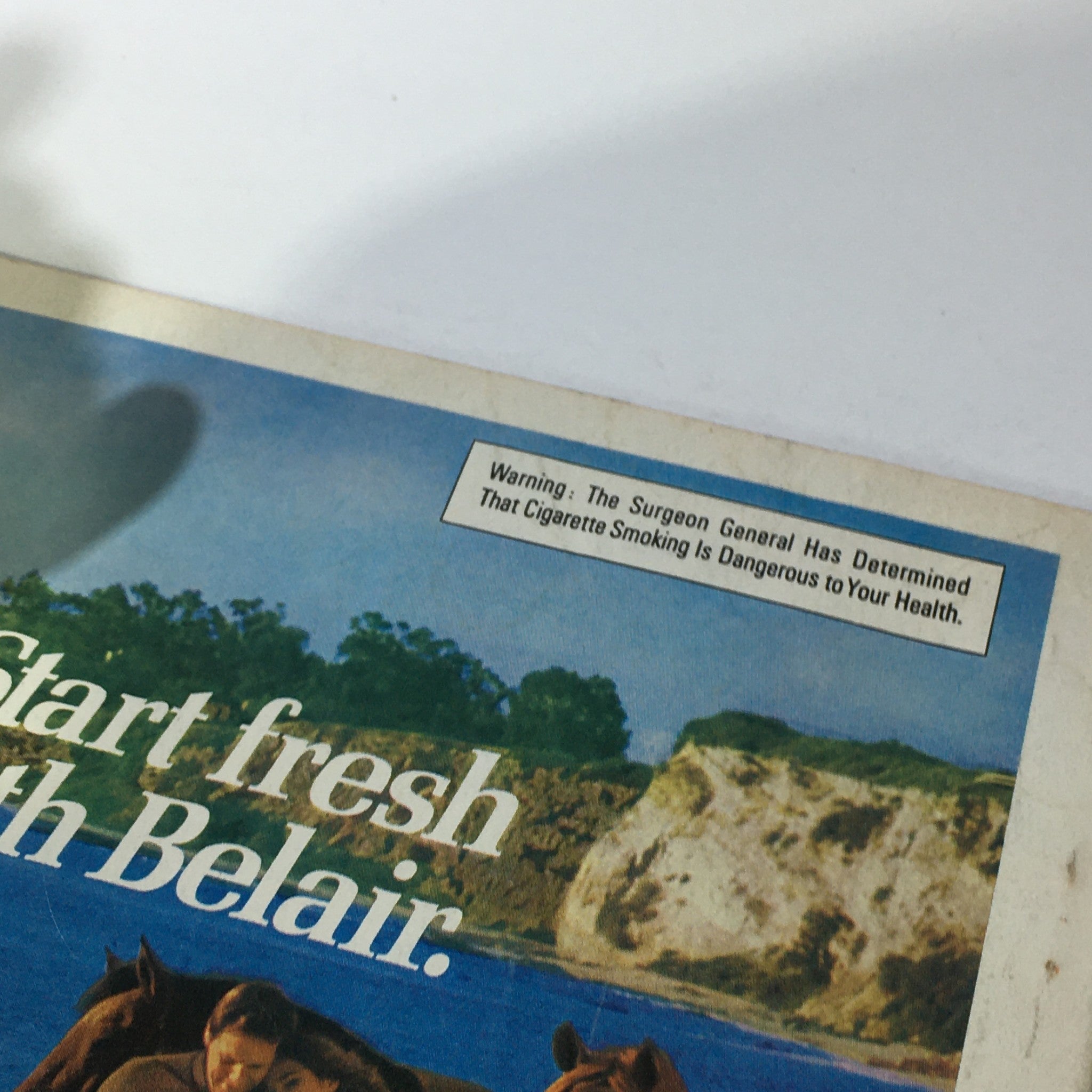 Back cover of the VTG Lady's Circle Magazine January 1976 with a warning about cigarette smoking, advertising 'Start fresh with Belair,' set against a picturesque outdoor scene.