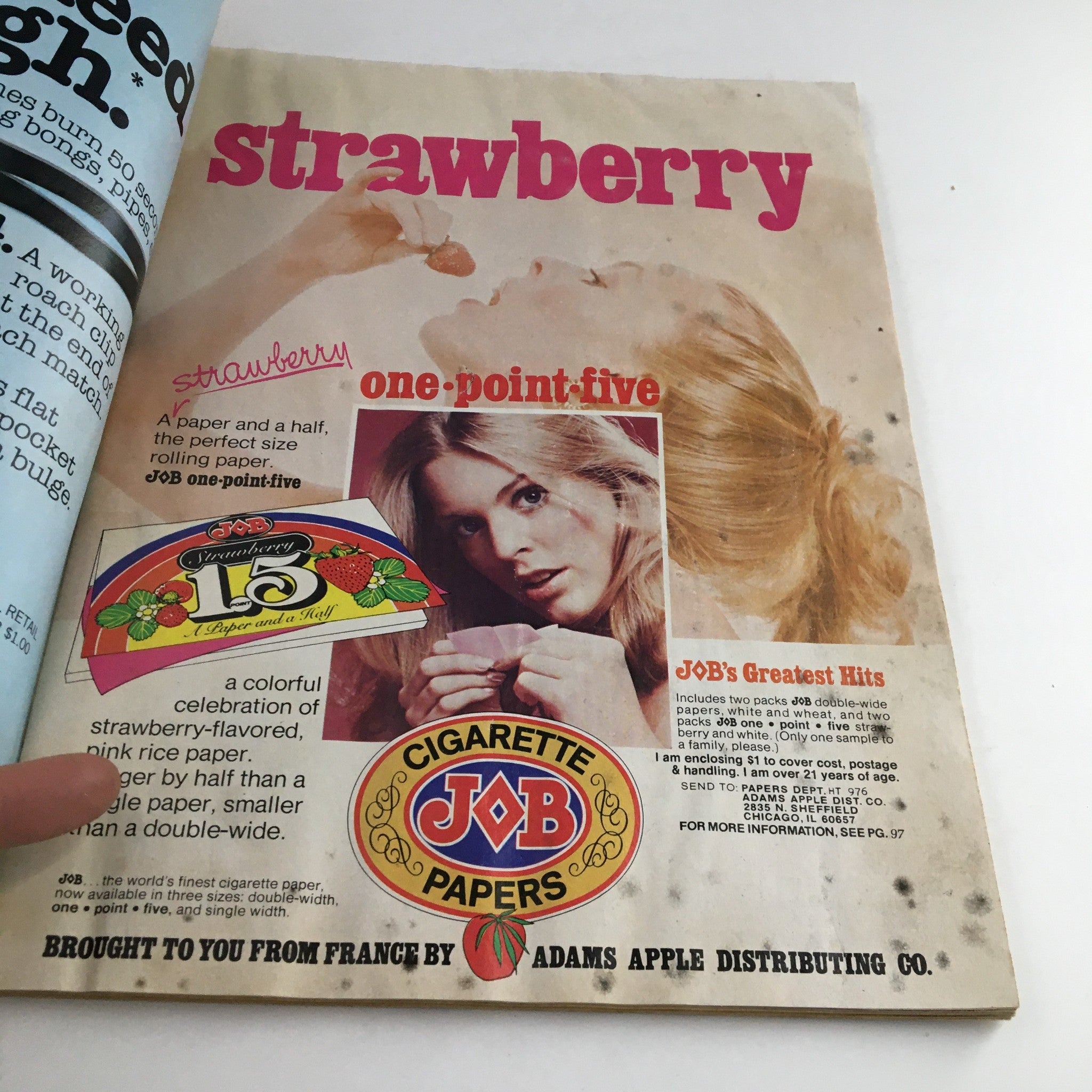 Interior page of High Times Magazine October 1976 showcasing an advertisement for JOB rolling papers with a vintage aesthetic and a model holding a strawberry.