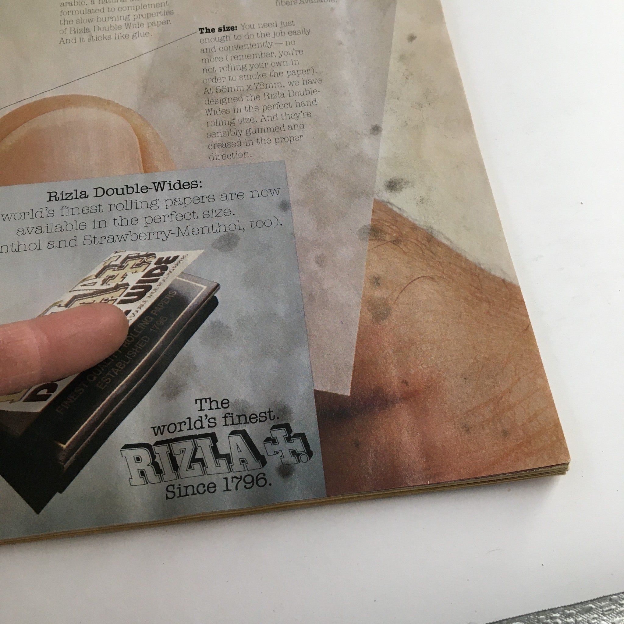 Interior advertisement from High Times Magazine October 1976 for Rizla rolling papers, displaying product details with a rustic background, highlighting its historical context in cannabis culture.