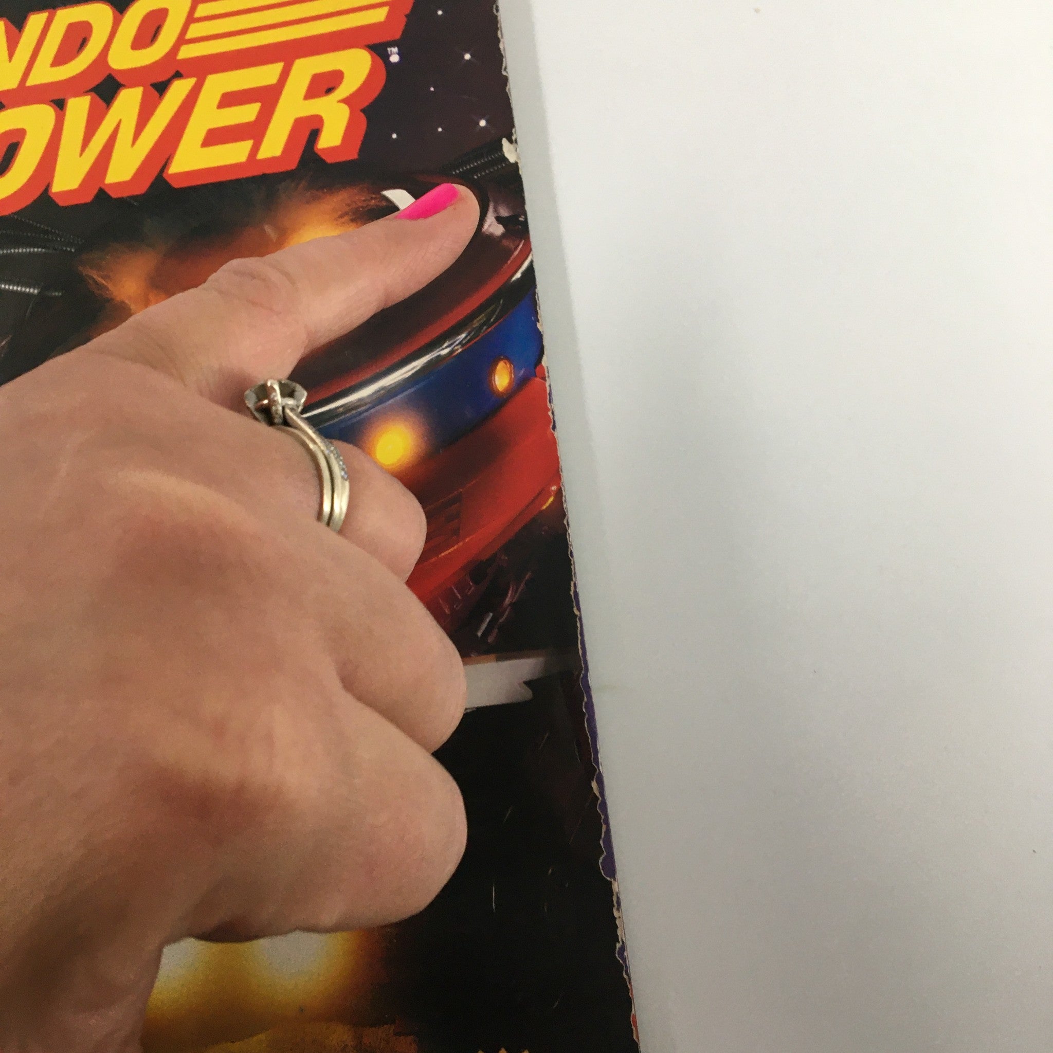 Close-up view of the cover edge of Nintendo Power Magazine August 1991, Issue #27, displaying the title and a finger pointing at the Dr. Wily's Revenge section.