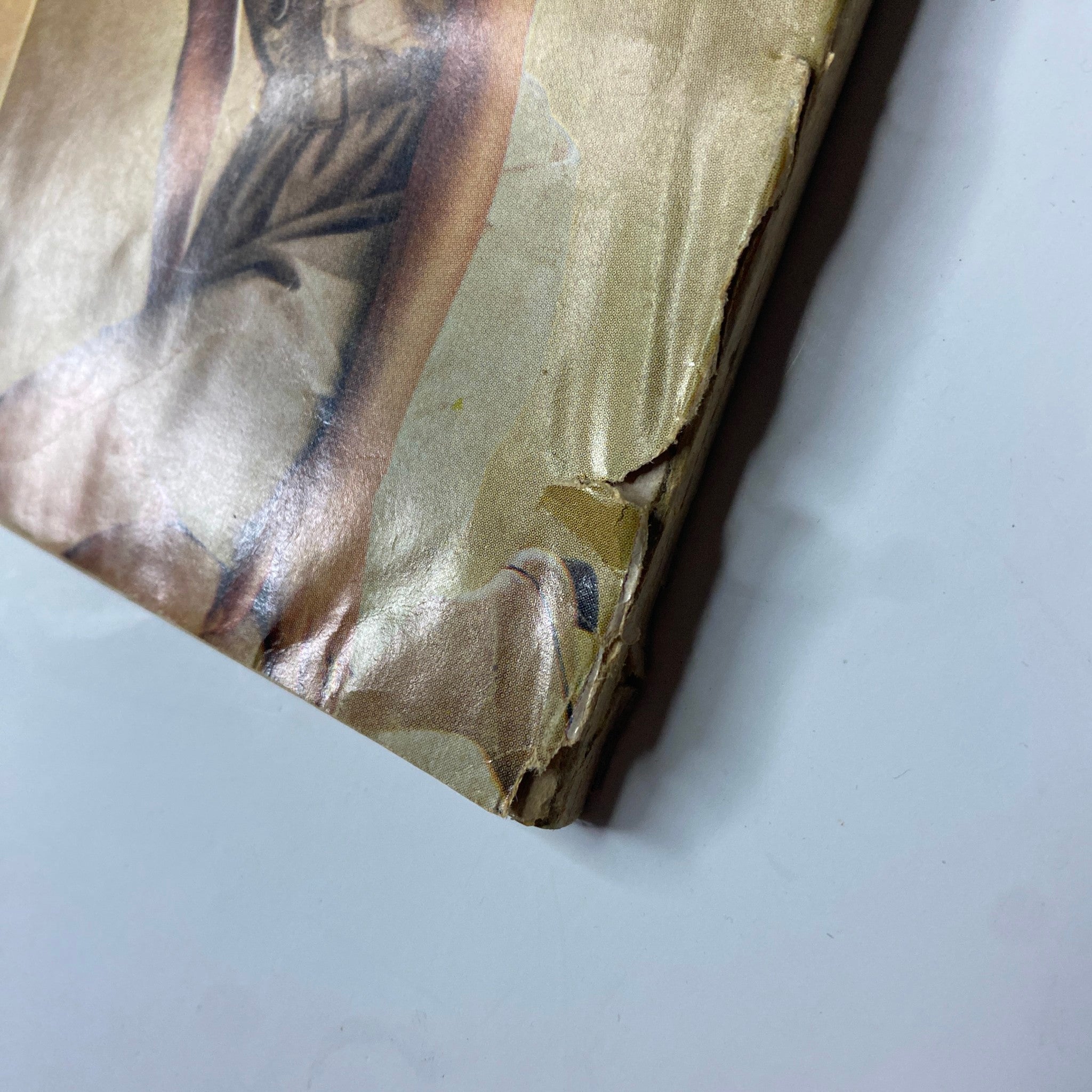Side view of a worn vintage magazine from Vogue Magazine January 1, 1969, highlighting damage to the cover, contributing to its historical value.