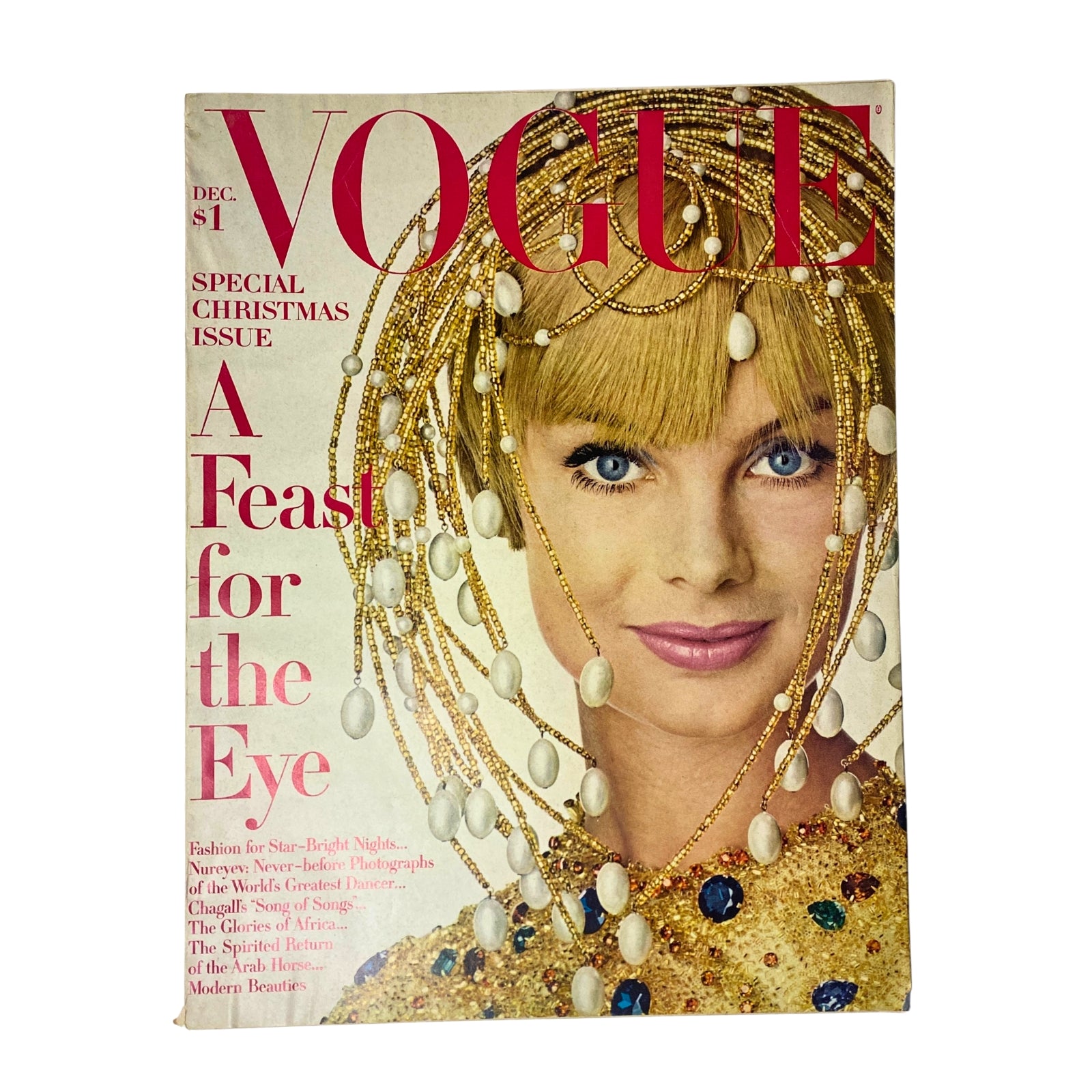 Vogue Magazine December 1967 featuring Jean Shrimpton on the cover with a festive, glamorous look, wearing a beaded headpiece and a golden outfit, celebrating the holiday season.