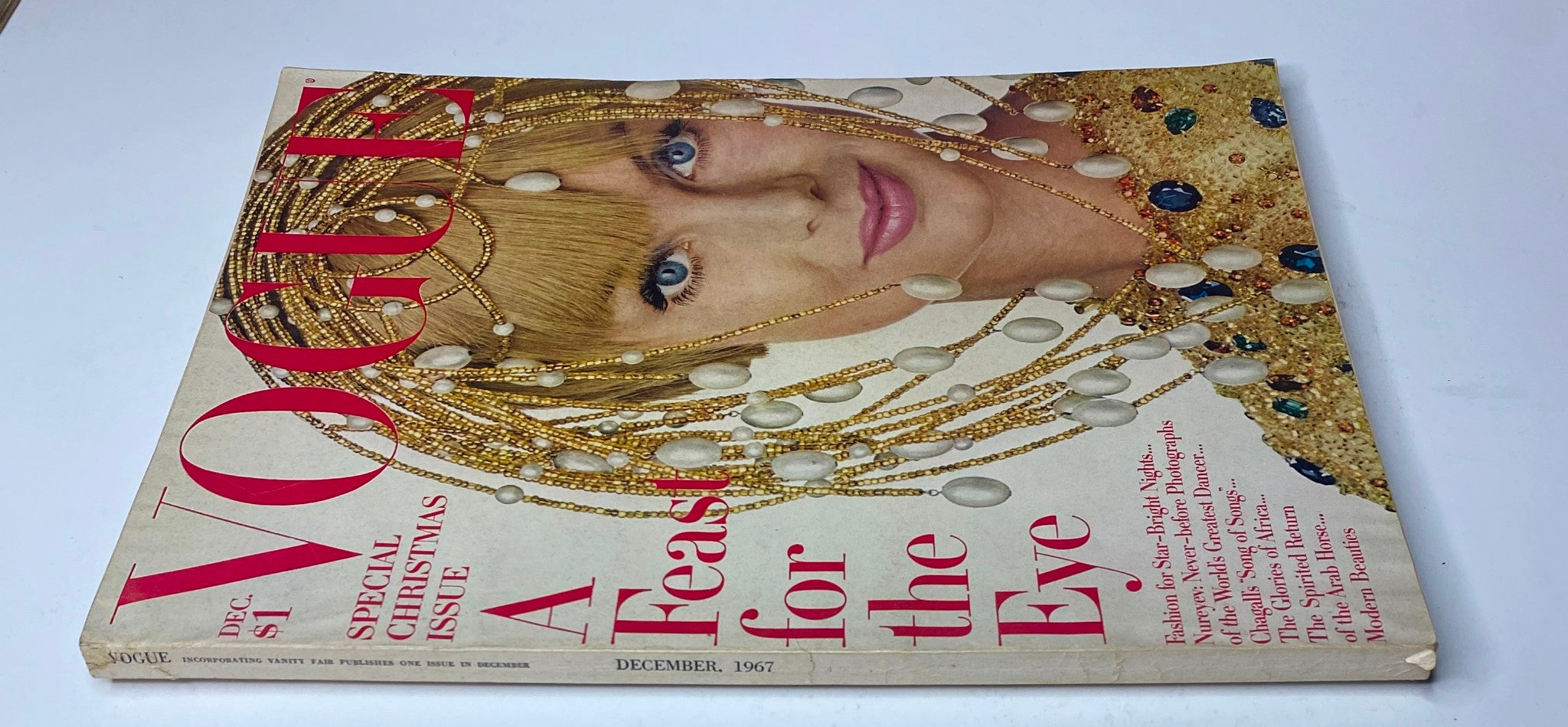 Vogue Magazine December 1967 cover featuring Jean Shrimpton adorned with decorative beads and jewelry, capturing the festive theme of the issue.