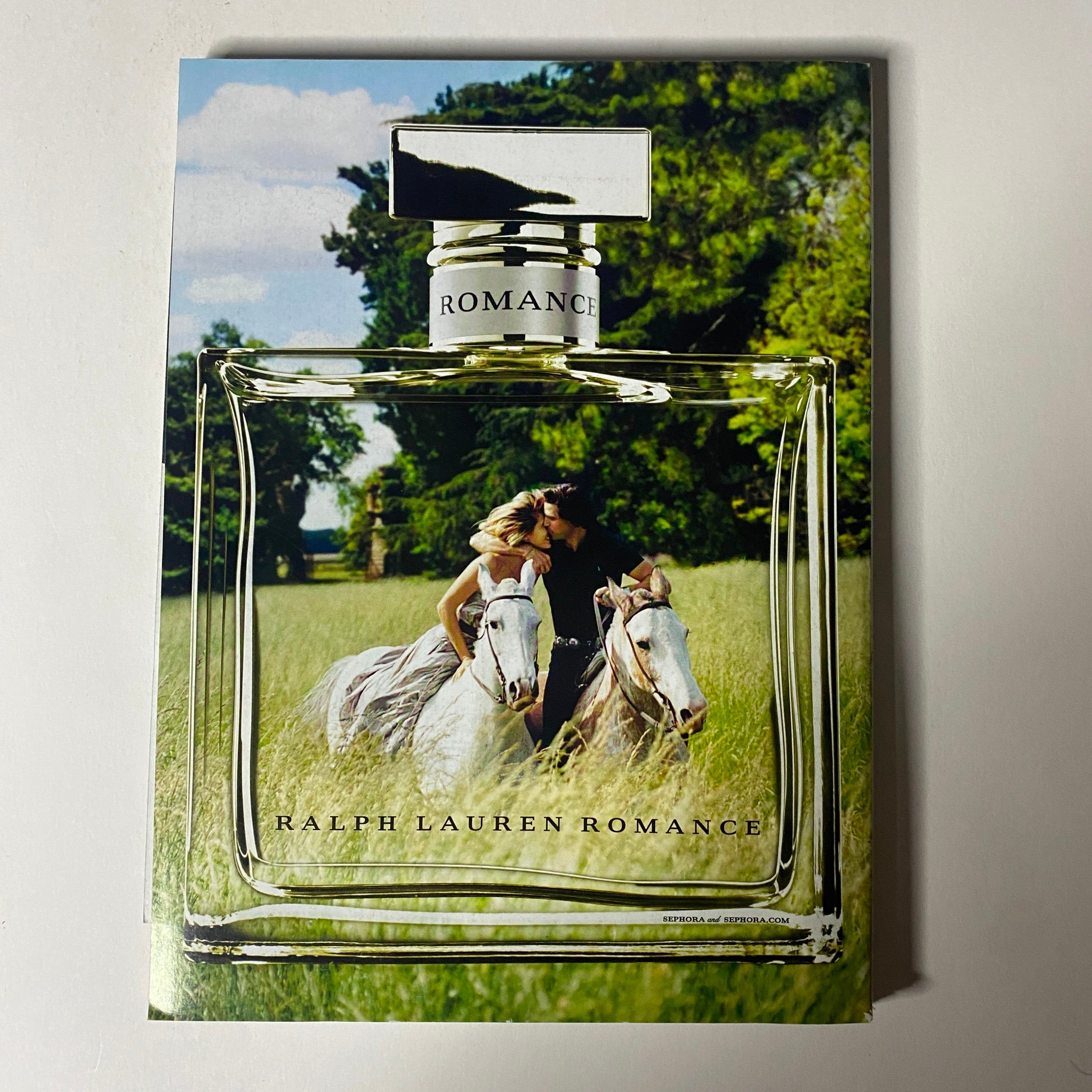 Ralph Lauren Romance advertisement from Vogue Magazine November 2013, illustrating the perfume with models on horseback in a lush field.