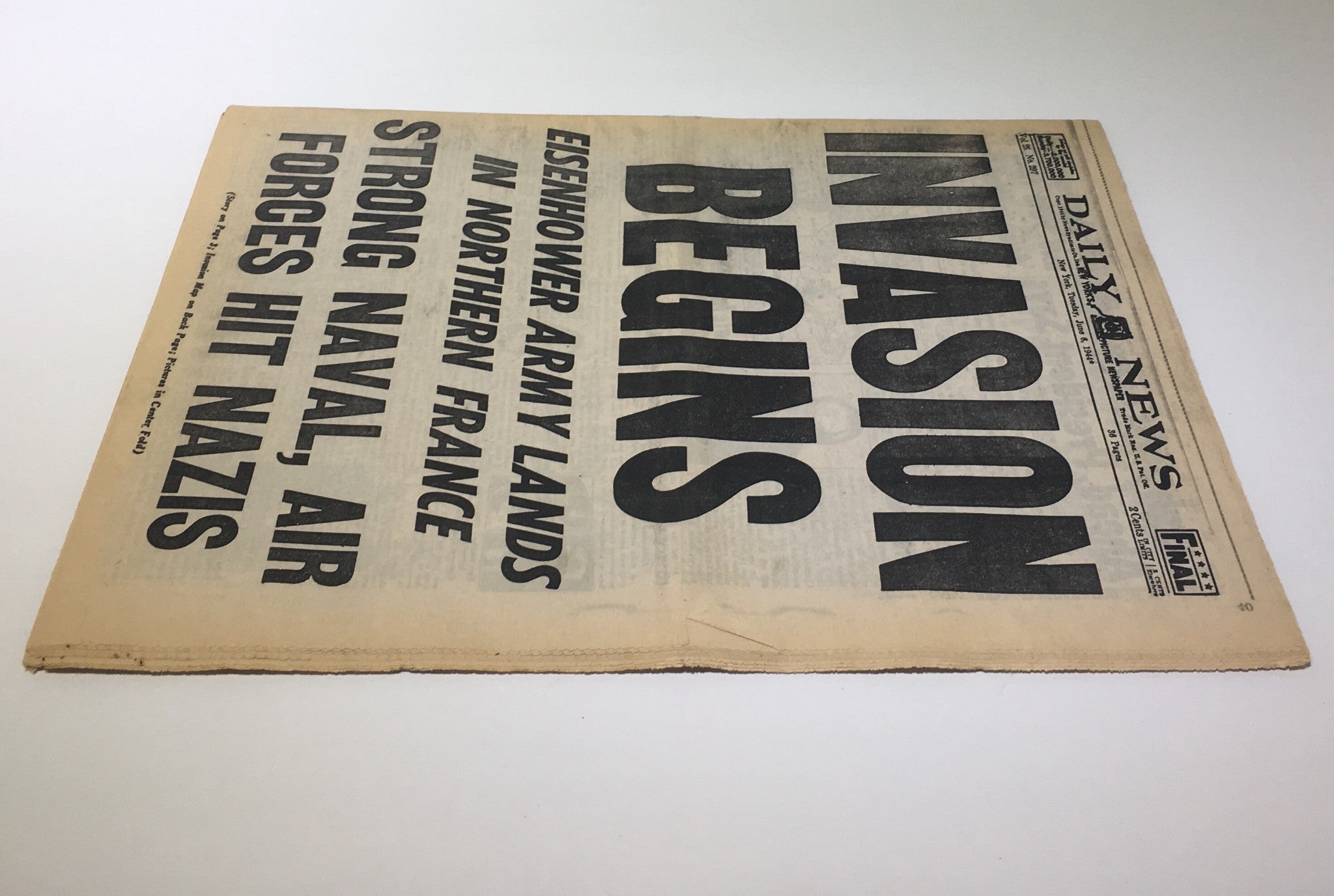 Side view of the front page of the NY Daily News: June 6 1944, highlighting the start of the invasion in Northern France with prominent text on military actions against Nazis.