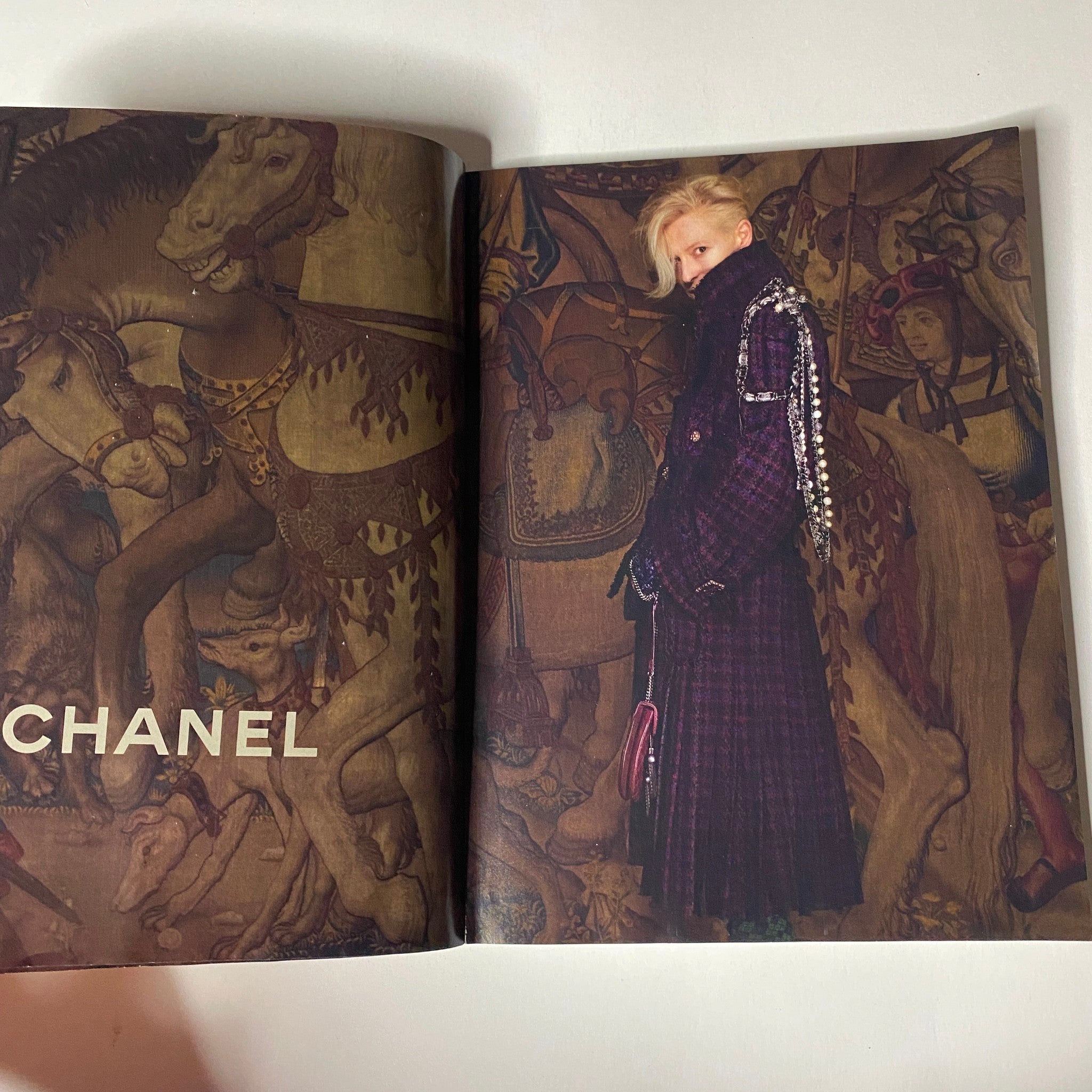 Chanel fashion spread from Vogue Magazine June 2013, featuring a model in a luxury coat against a detailed historical tapestry, showcasing high-fashion aesthetics.