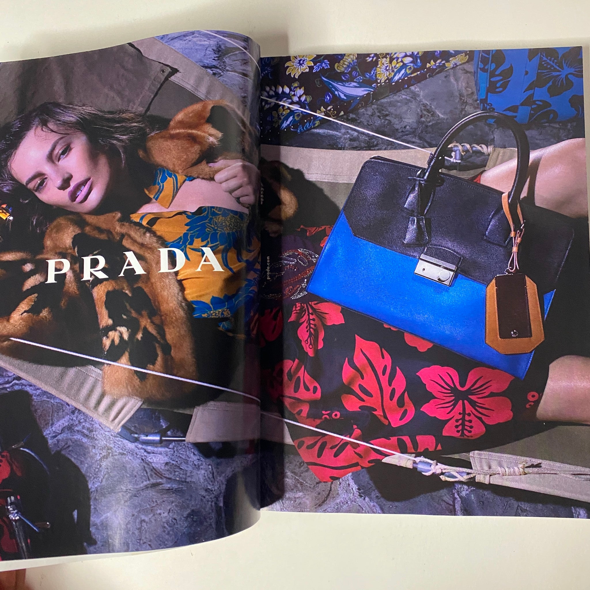 Fashion advertisement page from Vogue Magazine December 2013 for Prada, featuring a model draped in luxurious clothing and accessories, exemplifying high fashion.
